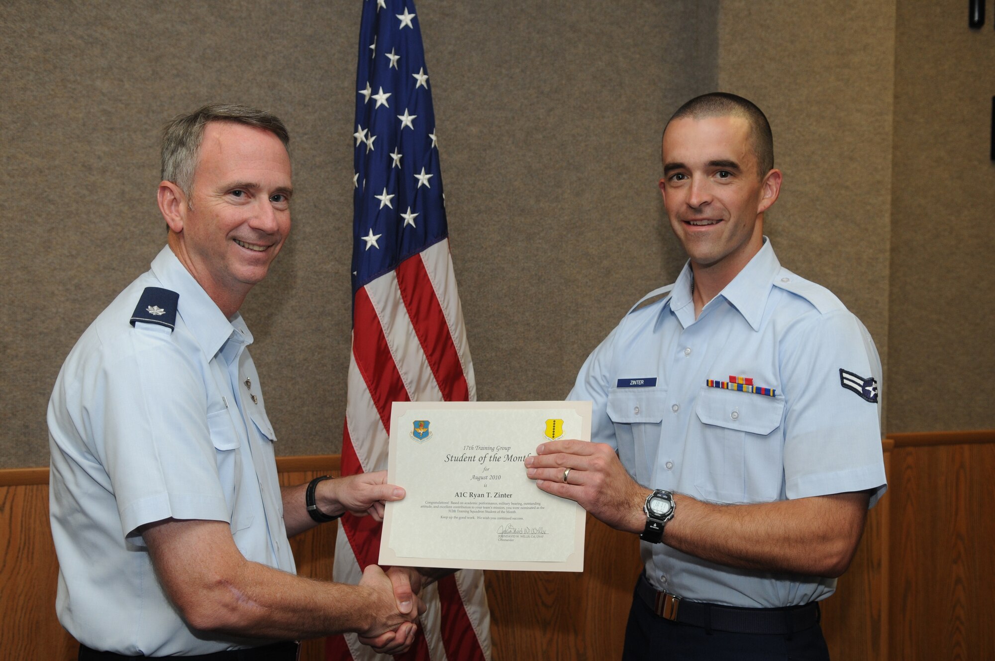 Airman 1st Class Ryan Zinter, 312th Training Squadron, accepts his August Student of the Month award from Lt. Col. Andrew Cupp, 17th Training Group Deputy Commander. (U.S. Air Force photo/Airman 1st Class Clayton Lenhardt)
