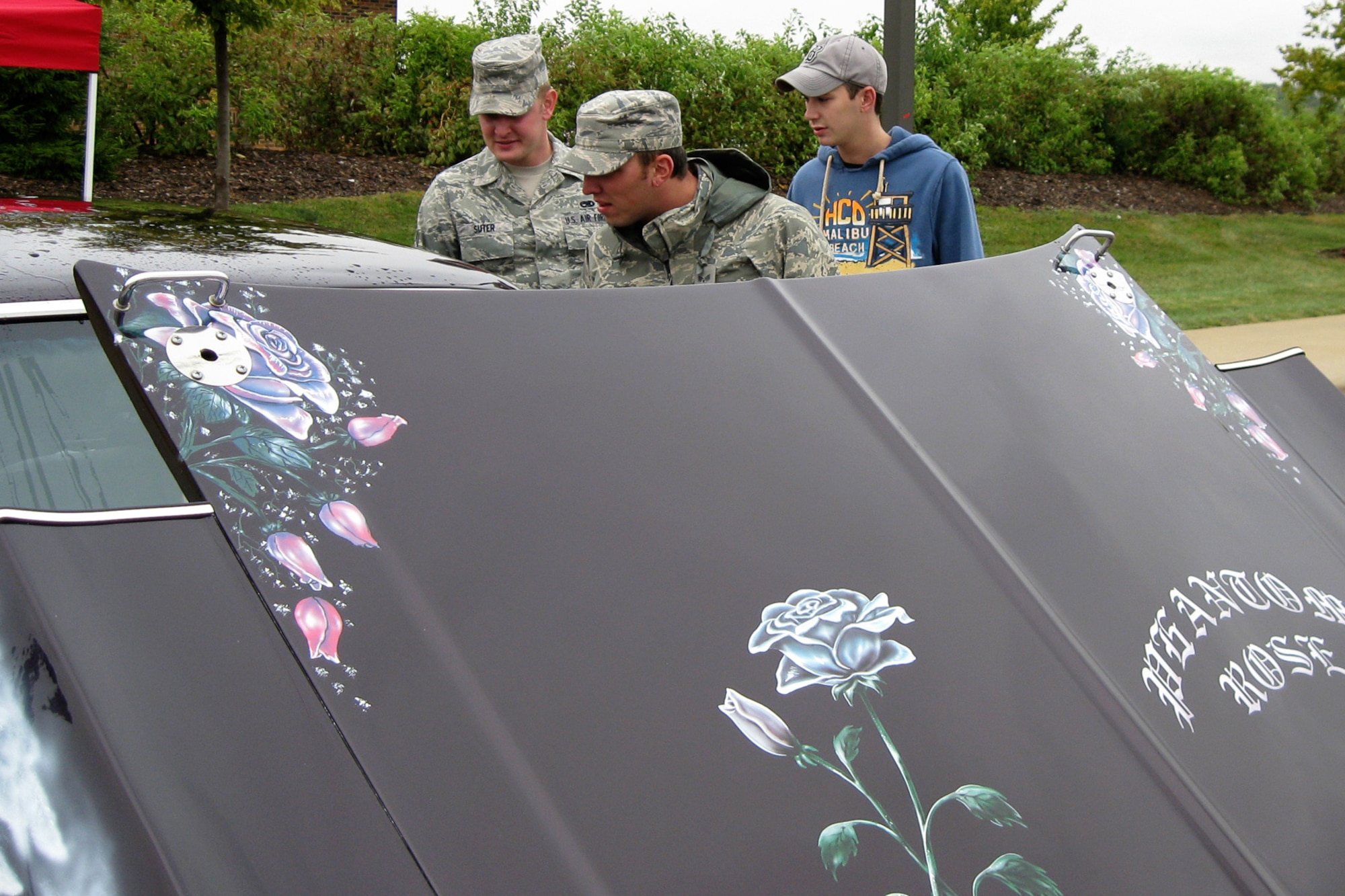 GRISSOM AIR RESERVE BASE, Ind. -- Senior Airmen Brad Suter, Colt Allen and Nathan Foxworth admire Bonita Snell's Phantom Rose. The 1971 Chevy Nova, restored from two separate cars by a husband and wife team in 28 days is part of a "His and Hers" set and was at Grissom as part of the Sept. 11 Family Day picnic. The Phantom Rose won the title of Best Paint. The Airmen are all assigned to the 434th Aircraft Maintenance Squadron. (U.S. Air Force photo/Capt. Kelly L. Howard)      