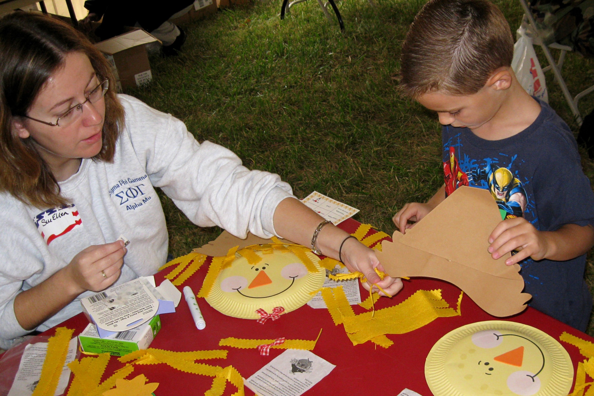 GRISSOM AIR RESERVE BASE, Ind. --  Tanner Floyd, 5, receives a little help from volunteer Sue Ellen Sopher on his paper-plate scarecrow craft project during Grissom's Family Day activities Sept. 11. Tanner is the son of Airman 1st Class Scott and Michelle Floyd. Scott is a member of the 434th Civil Engineer Squadron. (U.S. Air Force photo/Capt. Kelly L. Howard)