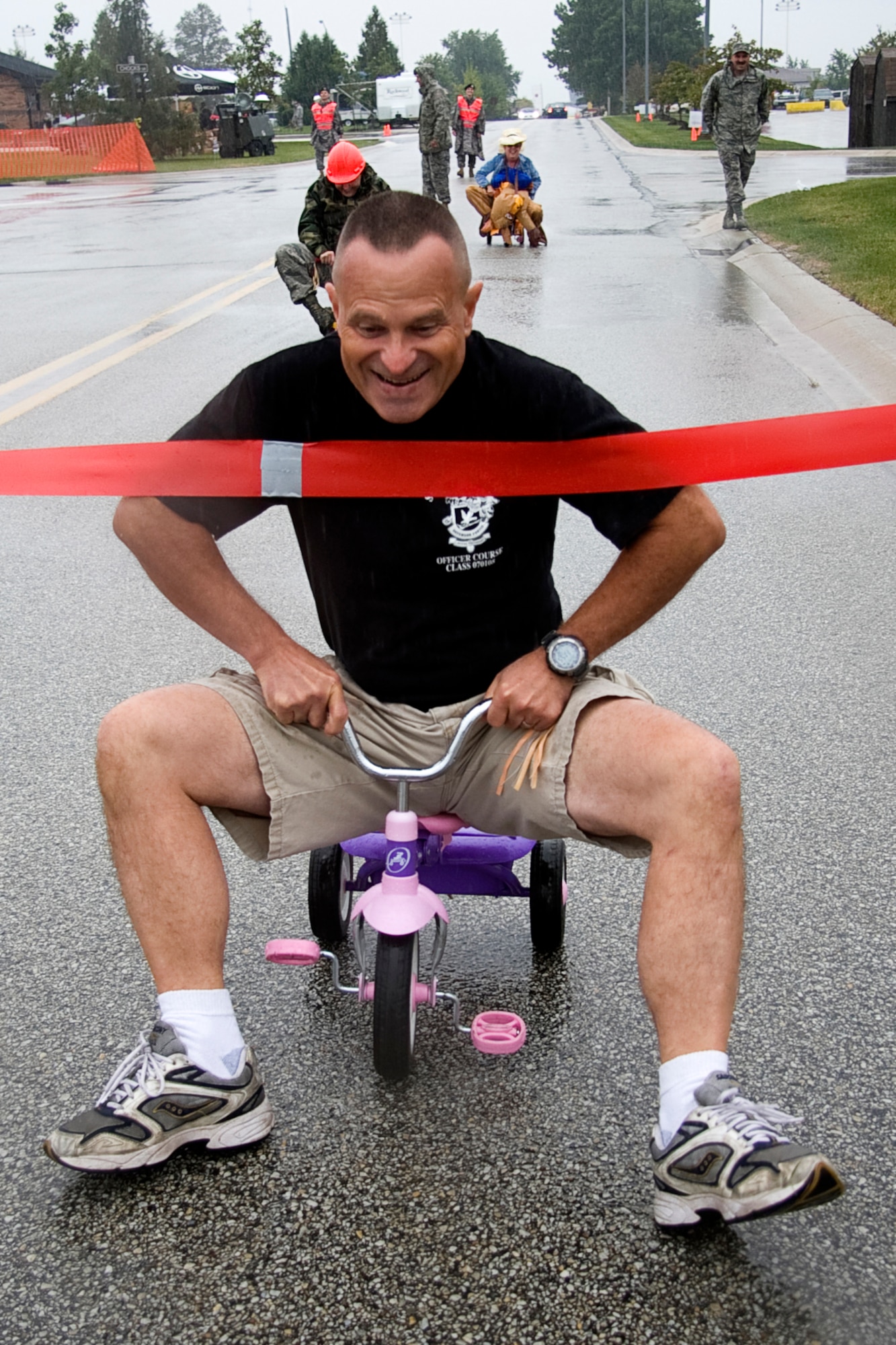 GRISSOM AIR RESERVE BASE, Ind. -- Maj. Ronald Jackson, 434th Security Forces Squadron operations officer, breaks through the finish line during a tricycle race held during a Family Day picnic here Sept. 11. Major Jackson beat out Lt. Col. Becky Fox, 434th Communications Squadron commander, and Master Sgt. Tina Youker, 434th Operations Group career assistance advisor. (U.S. Air Force photo/Tech. Sgt. Mark R. W. Orders-Woempner)

