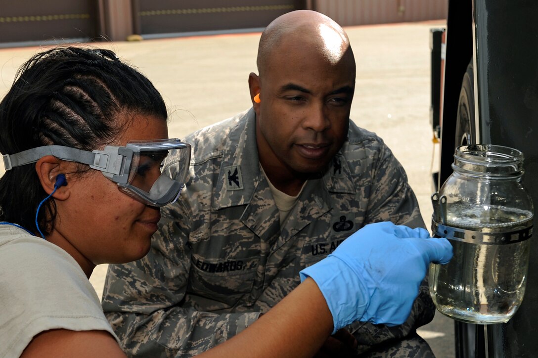 ELLSWORTH AIR FORCE BASE, S.D. -Airman 1st Class Angela Griffen, 28th Logistics Readiness Squadron fuels technician, demonstrates how to conduct a visual inspection of JP-8 jet fuel to Col. Trent Edwards, 28th Mission Support Group commander, Sept. 14.  The inspection examines fuel for any colors, water or sediment indicating impurities. (U.S. Air Force photo/Staff Sgt. Marc I. Lane)