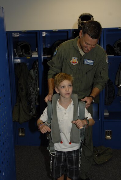 Major Adam Langton shows Preston Kilzer and his sister Kayli some aircrew flight equipment at the 125th Fighter Wing,Jacksonville Fla.  Preston and his family were in town with the Make A Wish Foundation and were given the opportunity to tour the base on September 13, 2010. (Air Force photo by Staff Sgt. Jaclyn Carver)