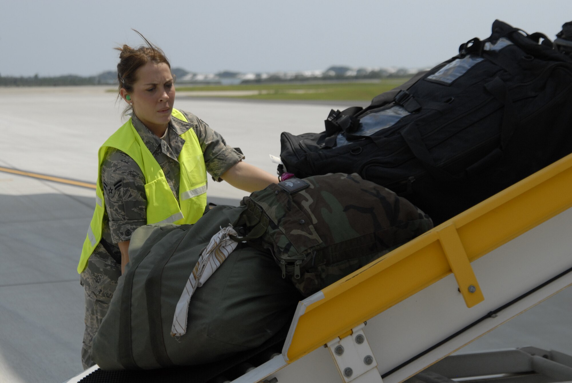 Airman 1st Class Kortney Bush, 1st Special Operations Support Squadron, unloads cargo from returning aircraft at the flight line at Hurlburt Field, Fla., Sept. 4, 2010. Airman Bush worked as an augmentee with the 1st Special Operations Logistics Readiness Squadron with baggage loading/unloading at the flight line. (DoD photo by U.S. Air Force Airman 1st Class Joe McFadden) (RELEASED)