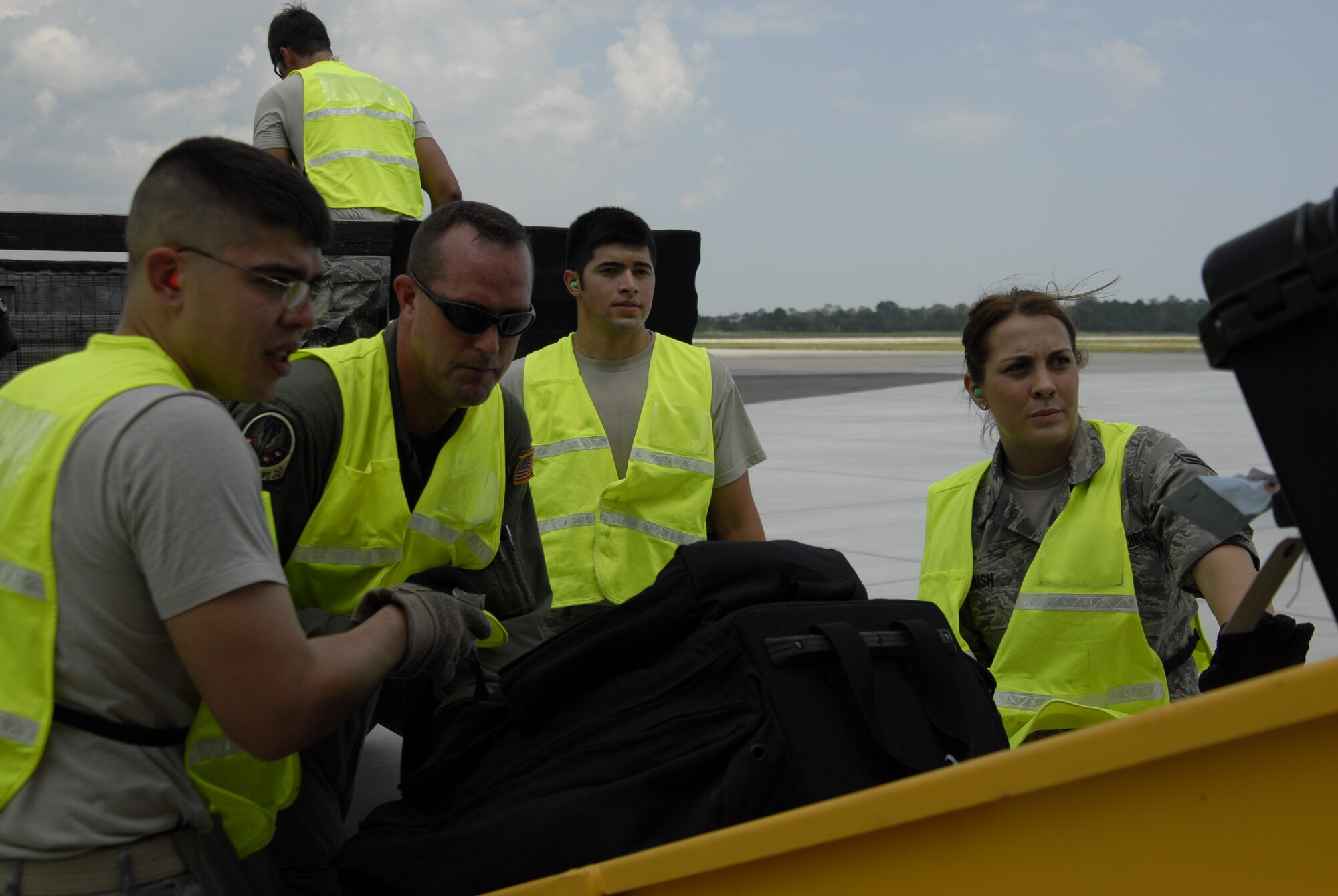 (From left to right) Senior Airman Ryan Brenner, 1st Special Operations Support Squadron, Staff Sgt. Stephen Critten, 15th Special Operations Squadron, Airman 1st Class Alex Almarales, 6th Special Operations Squadron, and Airman 1st Class Kortney Bush, 1st Special Operations Support Squadron, unload cargo from returning aircraft at the flight line at Hurlburt Field, Fla., Sept. 4, 2010. The Airmen worked as augmentees with the 1st Special Operations Logistics Readiness Squadron with the processing line at the Deployment Control Center and baggage loading/unloading at the flight line. (DoD photo by U.S. Air Force Airman 1st Class Joe McFadden) (RELEASED)