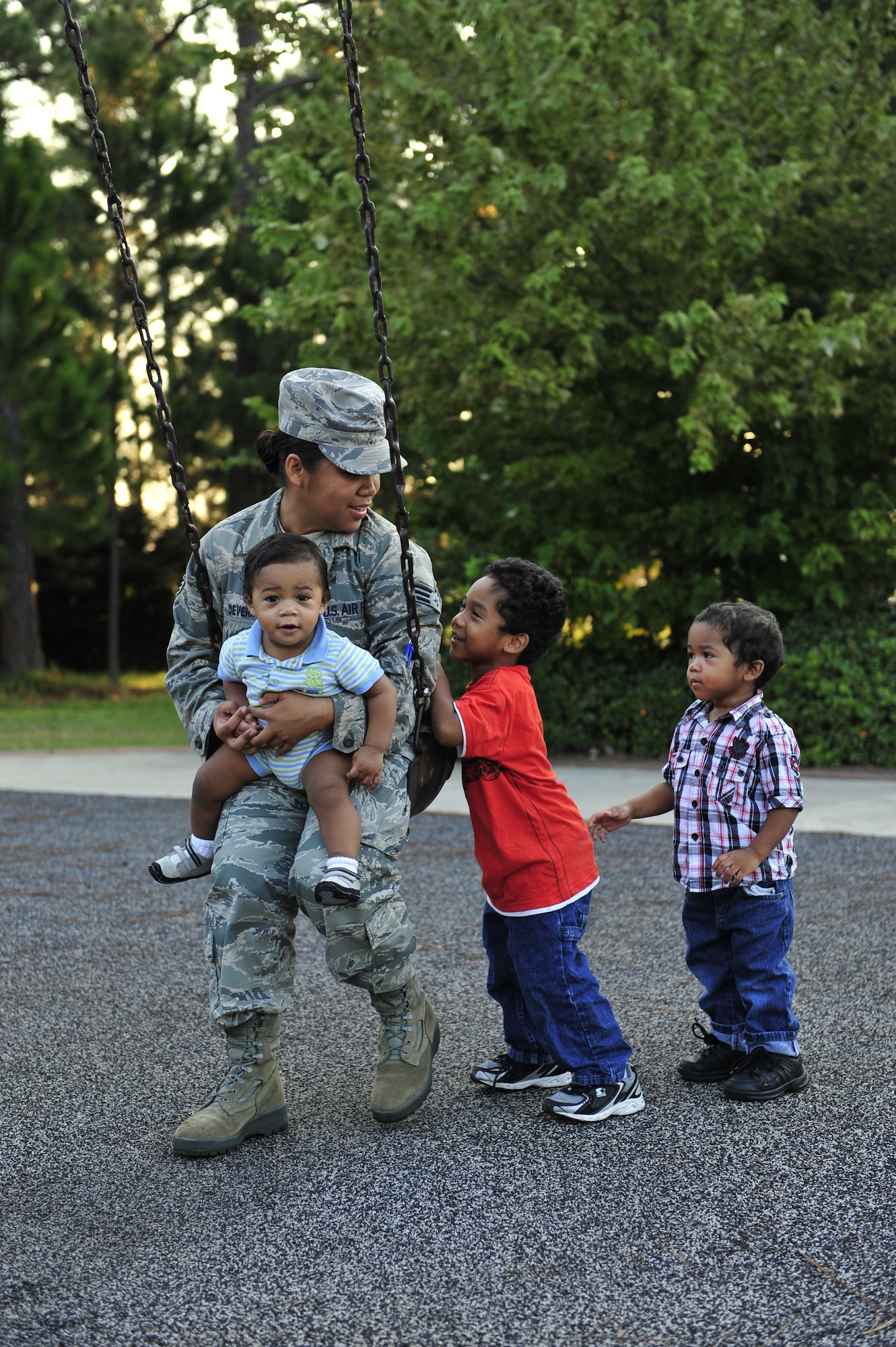 Senior Airman Sheila deVera, 1st Special Operations Wing Public Affairs photographer and single mother, holds her son Jaiden, nine months old, while being pushed on the swing by her other sons Brian Jr., 4, center, and Daeshawn, 2, right, at a playground at Hurlburt Field, Fla., Sept. 15, 2010.  The Airman & Family Readiness Center holds a single parent support group meeting on the fourth Tuesday of every month for single parents to share their experiences and draw lessons from others. (DoD photo by U.S. Air Force Staff Sgt. Stephanie Jacobs) (RELEASED)