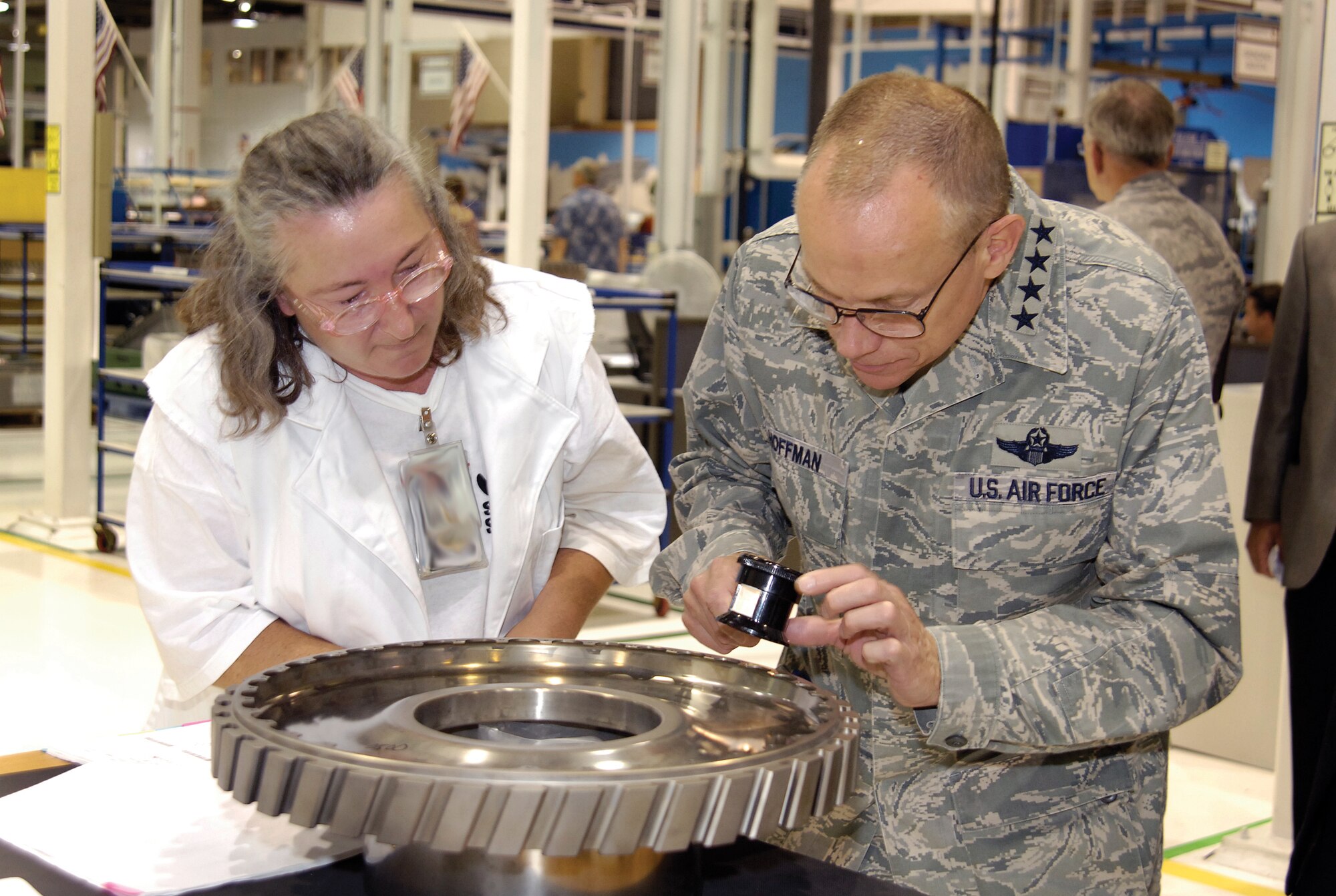 Tinker machinist Debbie Medina shows Gen. Donald Hoffman, commander of Air
Force Materiel Command, a nick she discovered in an F100 third-stage disk
during a visual inspection. The AFMC commander came to Tinker Sept. 9 and 10
to visit shops across base. Ms. Medina is with the 76th Propulsion Maintenance Squadron and works in Bldg. 3001. (U.S. Air Force photo/Margo
Wright)

