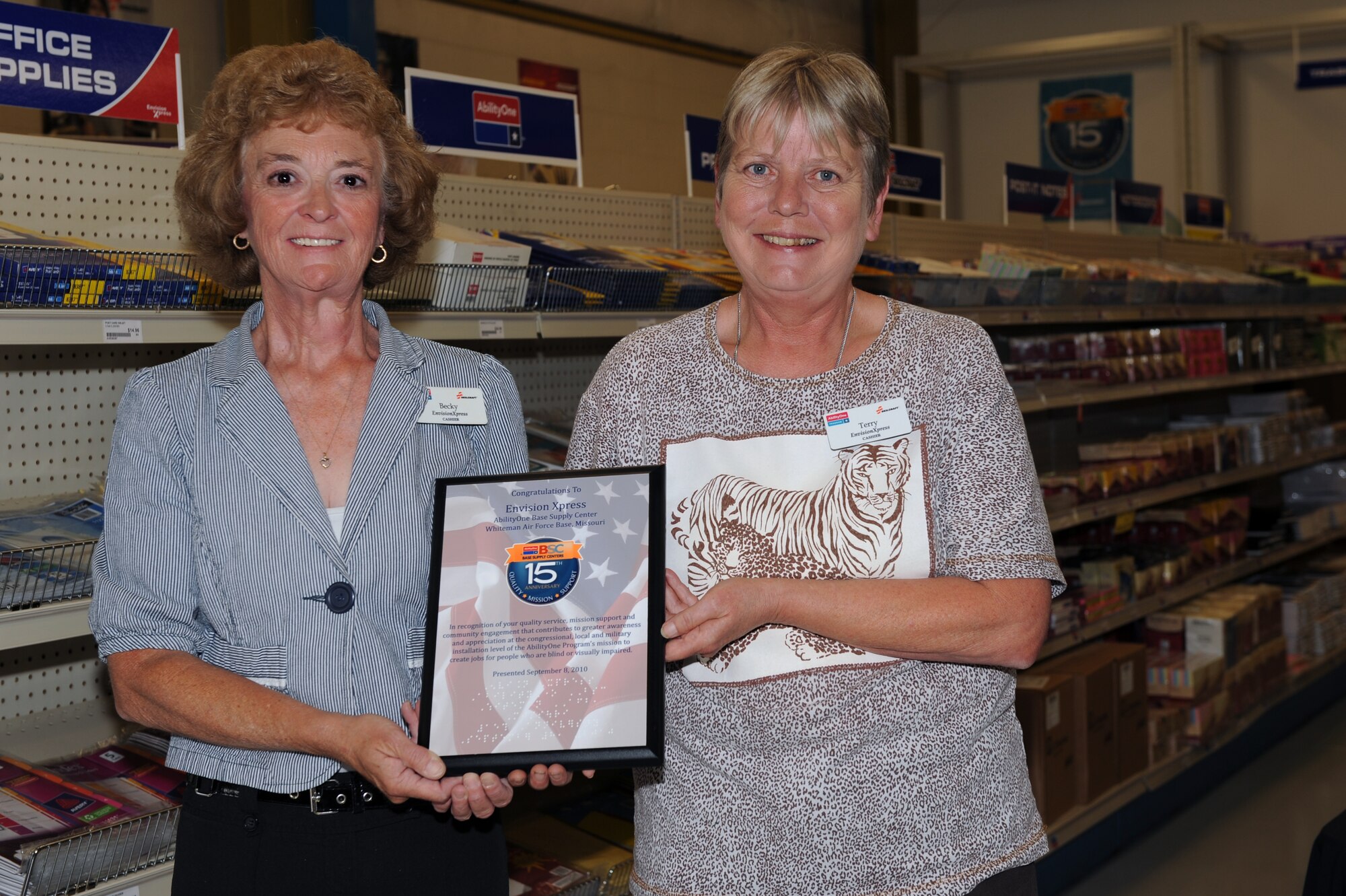 WHITEMAN AIR FORCE BASE, Mo., -- Becky Coombes and Terry Thompson, cashiers at the Envision store hold up a plaque celebrating 15 years of supplying base units with mission essential products to execute the Air Force Global Strike Command mission. In 1988, Congress declared October as National Disability Employment Awareness Month.
(U.S. Air Force photo/Staff Sgt. Jason Huddleston (Released)
