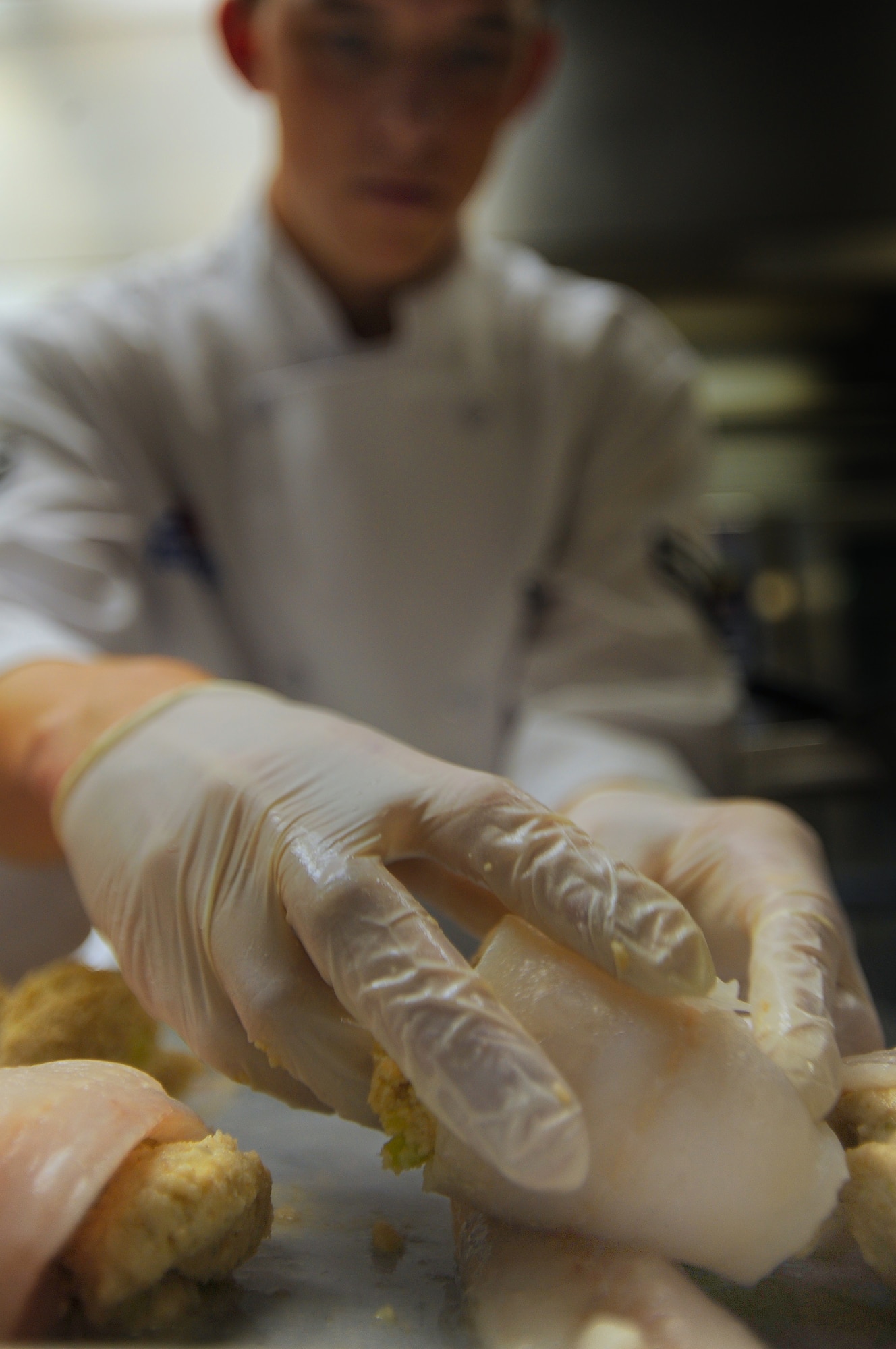 WHITEMAN AIR FORCE BASE, Mo., -- Airman 1st Class Justin Stewart, 509th Force Support Squadron Food Services technician, prepares stuffed fish as a part of the midday chow menu, Sept. 13. The 509th FSS Airmen operate with more than 400 recipes and prepare food for nearly 3,500 Airmen each week. (U.S. Air Force photo by Senior Airman Kenny Holston)(Released)

