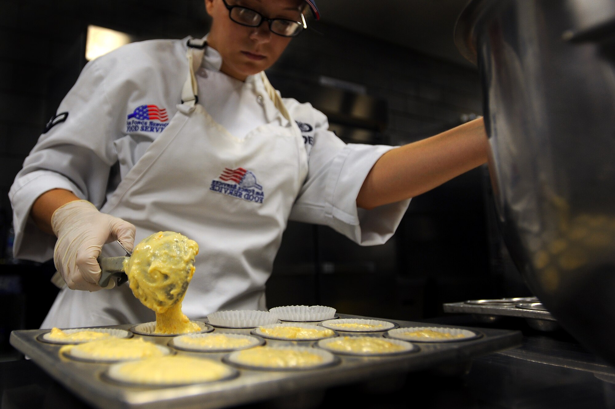 WHITEMAN AIR FORCE BASE, Mo., -- Airman Amber Rabideau, 509th Force Support Squadron, Food Services technician, prepares cheese biscuits for midday chow, Sept. 13. The 509th FSS Airmen operate with more than 400 recipes and prepare food for nearly 3,500 Airmen each week.   (U.S. Air Force photo by Senior Airman Kenny Holston)(Released)

