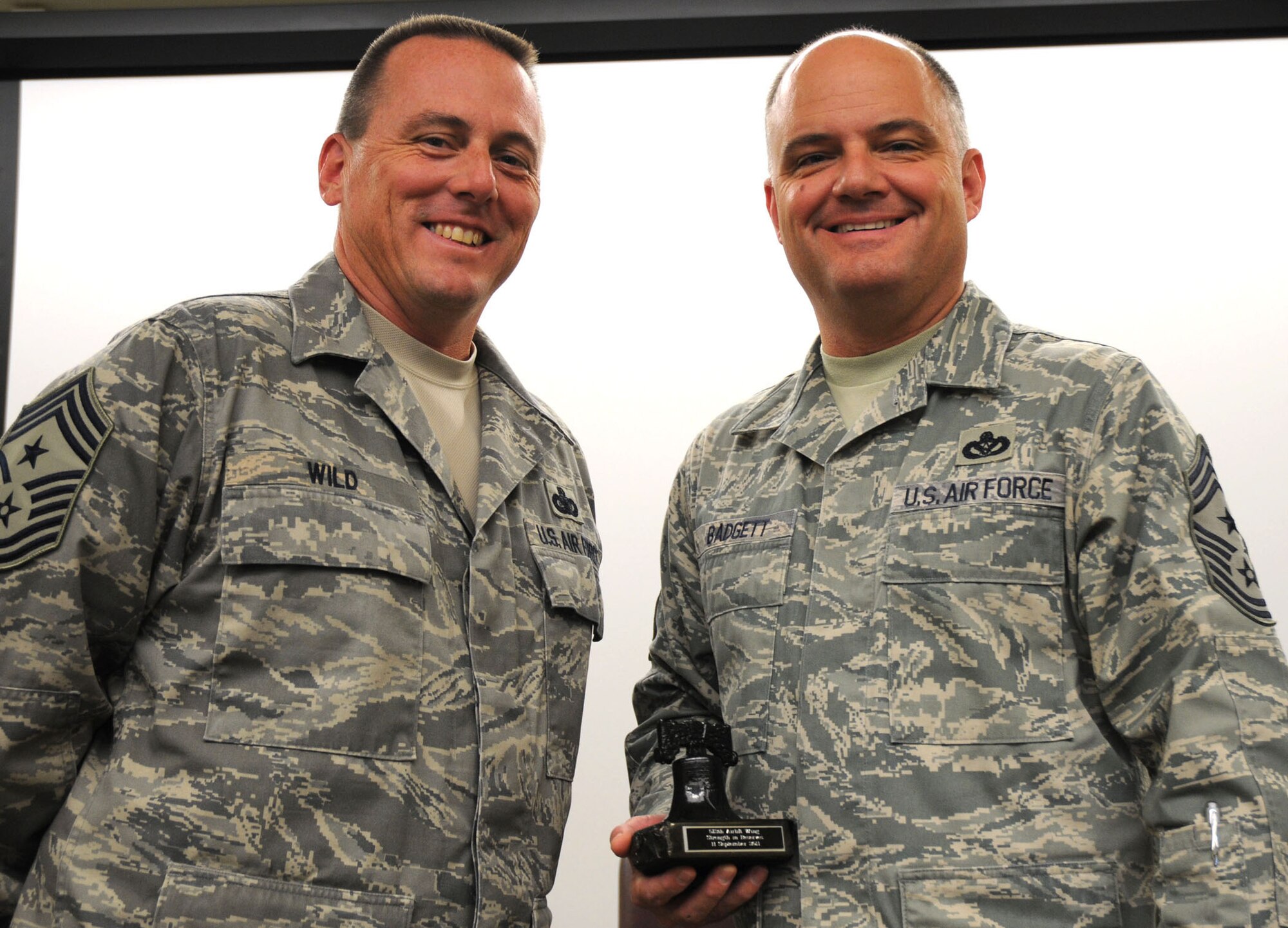 The 512th Airlift Wing Command Chief Master Sgt. William T. Wild III poses after giving a gift of appreciation to Chief Master Sgt. Dwight D. Badgett, Command Chief Master Sergeant for Air Force Reserve Command, during Airmen's Weekend at Dover Air Force Base, Del., Sept. 11, 2010. Command Chief Badgett spoke about the current state of the Reserve and answered questions during the Liberty Wing's annual "re-blueing" event. (U.S. Air Force photo by Senior Airman Andria J. Allmond/released) 