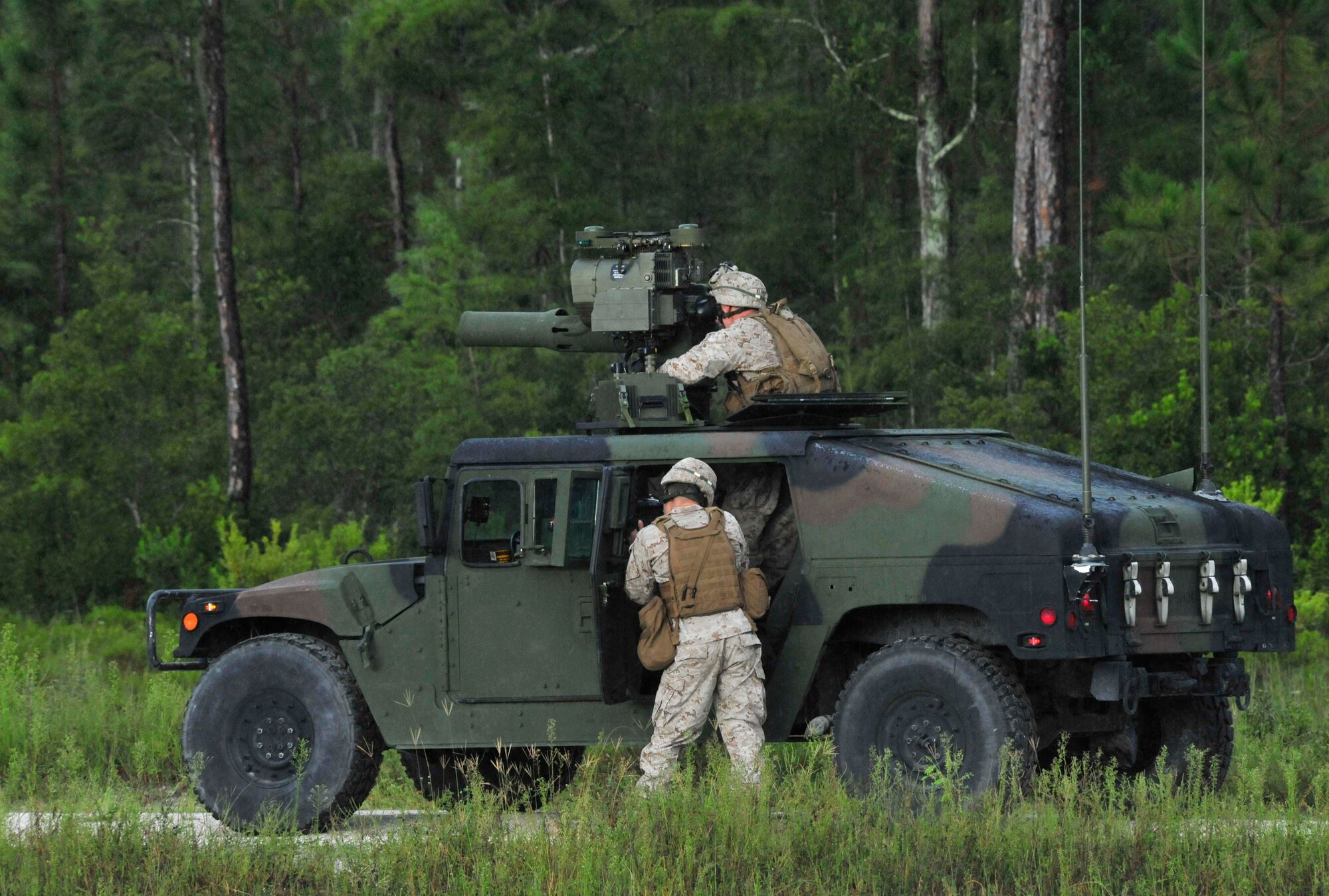 AVON PARK, Fla. -- Two Marines return fire as their vehicle takes small arms fire while they where doing their patrol on the convoy lane at Atlantic Strike 10-02, Sept. 13, 2010.  The convoy lane takes place along a rural road and focuses on counter improvised explosive device techniques and positively identifying targets with the type two tactical air control party close air support system, a video downlink which allows the joint terminal attack controller to see what the pilots see, eliminating error location factors.  Atlantic Strike is a biannual Air Combat Command sponsored joint training exercise designed for the tactical employment of air power in support of joint terminal attack controller and joint fires observer integration through close air support. (Air Force photo/Staff Sgt. Patrick Mitchell)
