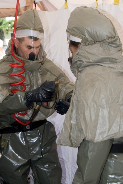 KUNSAN AIR BASE, Republic of Korea -- Airmen from the 8th Medical Group simulate cleansing one another after handling a contaminated member during a decontamination exercise at Kunsan Air Base, Republic of Korea, Sept. 15. Air Force bases worldwide conduct similar exercises in order to provide hands on training for medical personnel when dealing with decontamination procedures. (U.S. Air Force photo/Staff Sgt. Jonathan Pomeroy) 