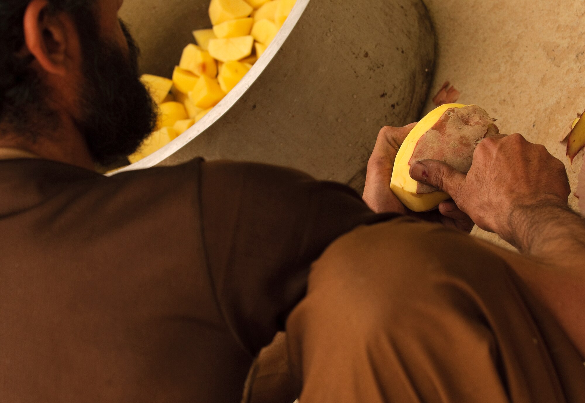 FORWARD OPERATING BASE BULLARD, Afghanistan - An Afghan cook peels potatoes for a traditional Afghan meal for elders during an election shura at the Shah Joy District Center, Shah Joy District, Zabul province, Sept. 13. Shah Joy District Chief Abdul Qayum invited local elders to the district center to discuss the upcoming provincial parliamentary elections and to celebrate the end of Ramadan. (U.S. Air Force Photo/Senior Airman Nathanael Callon/Released)
