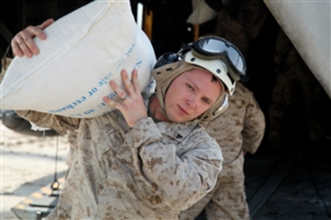 A U.S. Marine Corps corporal from the 26th Marine Expeditionary Unit unloads a bag of flour from a CH-53E Sea Stallion helicopter in support of the flood relief effort in Pano Aqil, Pakistan, on Sept. 11, 2010.  