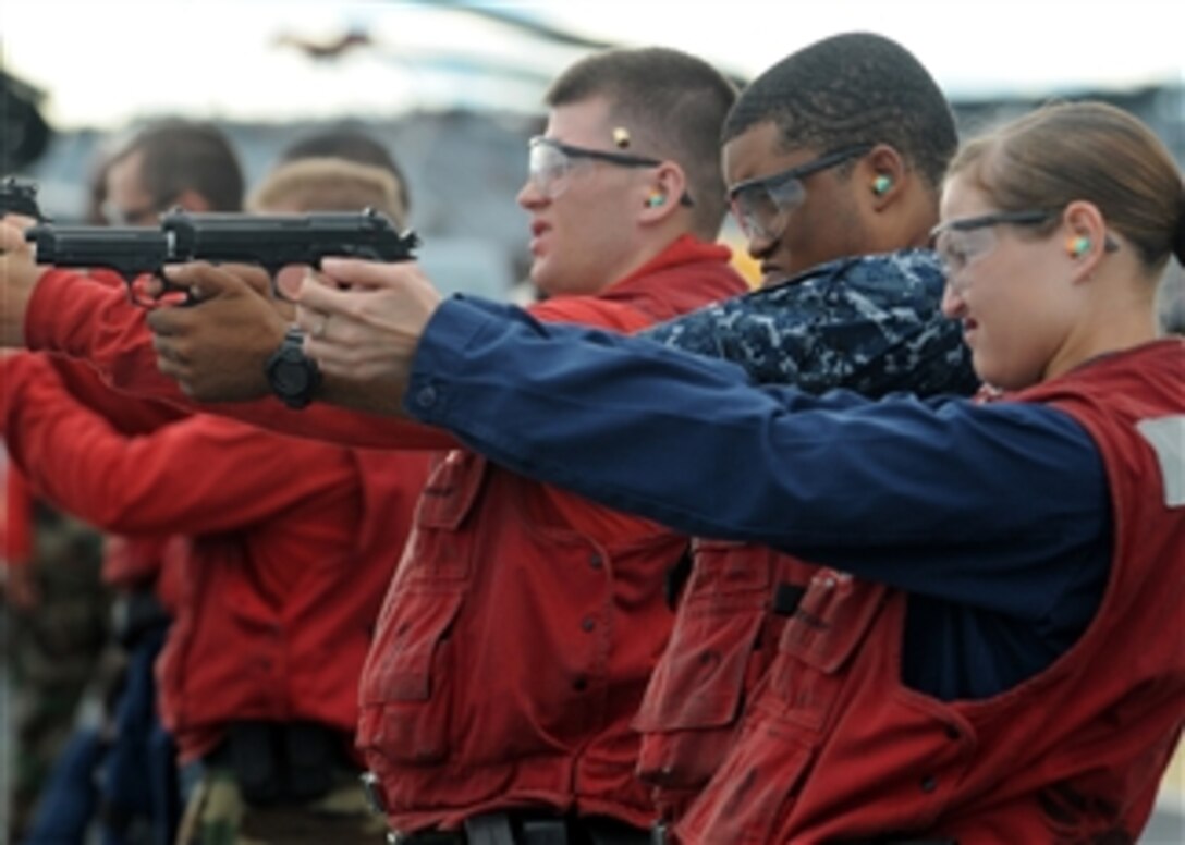 U.S. Navy sailors aboard the amphibious assault ship USS Essex (LHD 2) fire 9 mm Beretta pistols during a small arms shoot in the Philippine Sea on Sept. 13, 2010.  The Essex, part of the forward-deployed Essex Amphibious Ready Group, was participating in Valiant Shield 2010, a joint U.S. military exercise in the Pacific.  