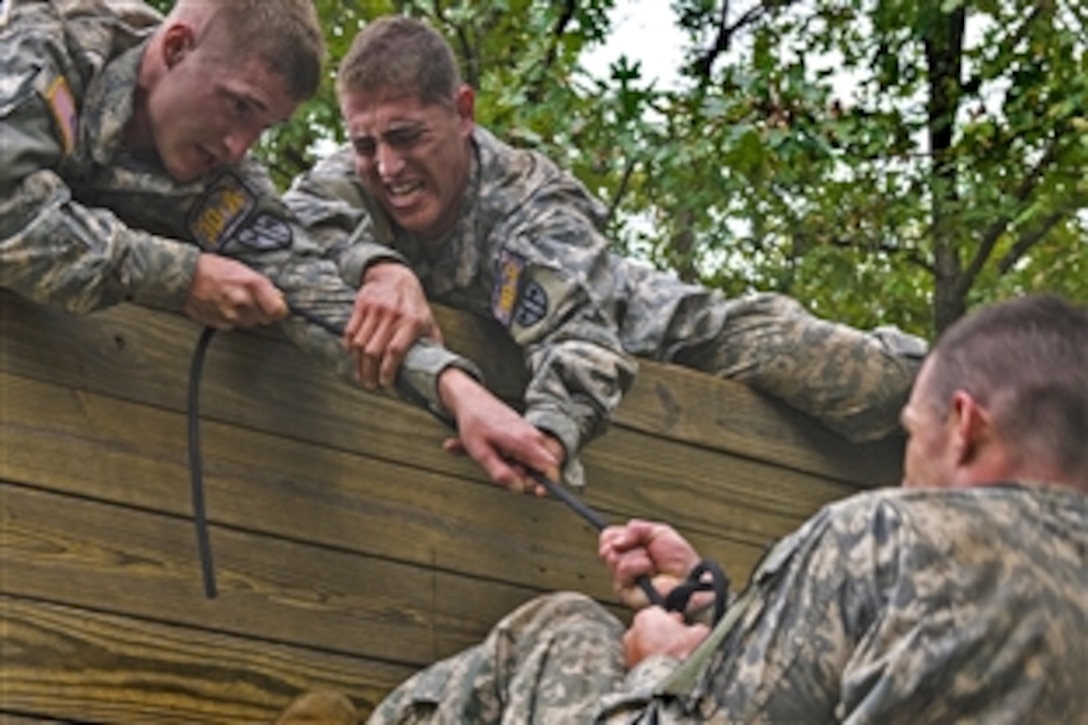 U.S. soldiers attempt to pull a comrade over a 15-foot wall on the obstacle course during the Army Warfighter Challenge on Fort Leonard Wood, Mo., Sept. 14, 2010. The annual competition brings Military Police units throughout the Army together to determine who is the best in the MP field.