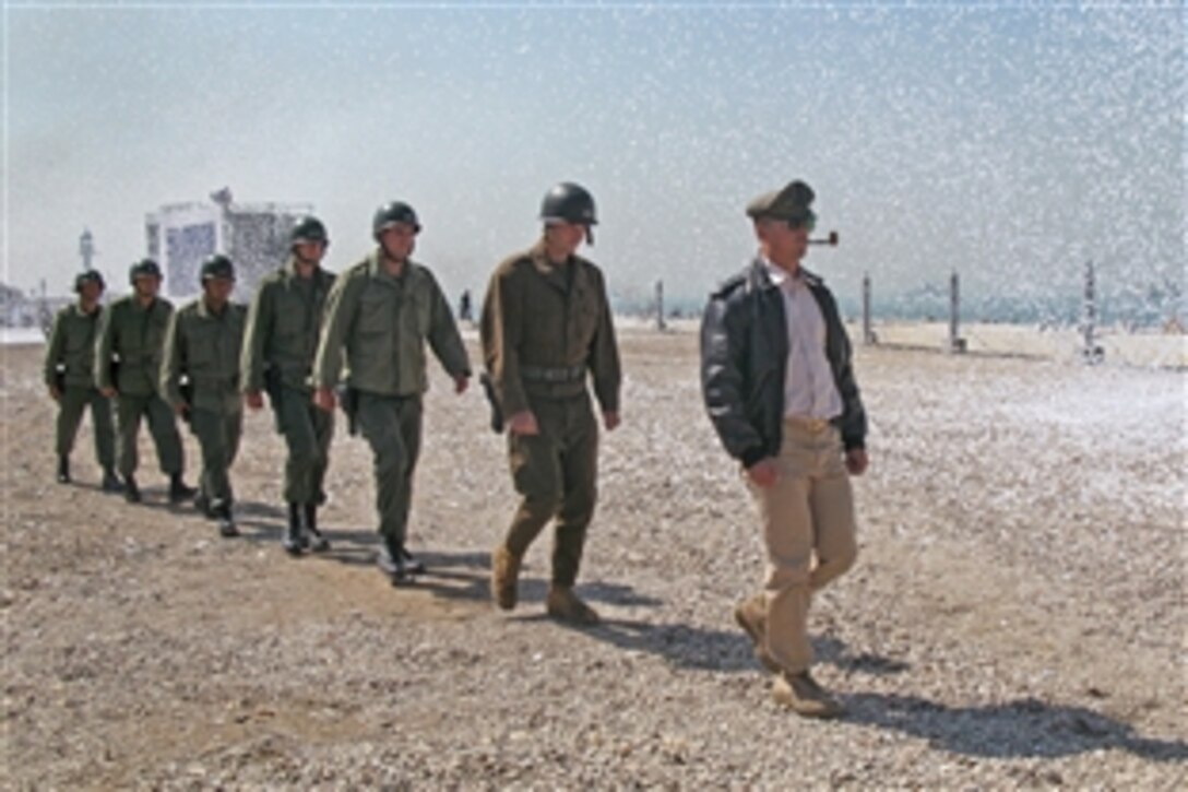 Army Gen. Douglas MacArthur, depicted by Marine Capt. Michael Borneo, right, marches across the beach amid a flurry of confetti, with fellow Marines depicting his key officers in tow during reenactment ceremonies of the Inchon Landing in South Korea, Sept. 15, 2010.