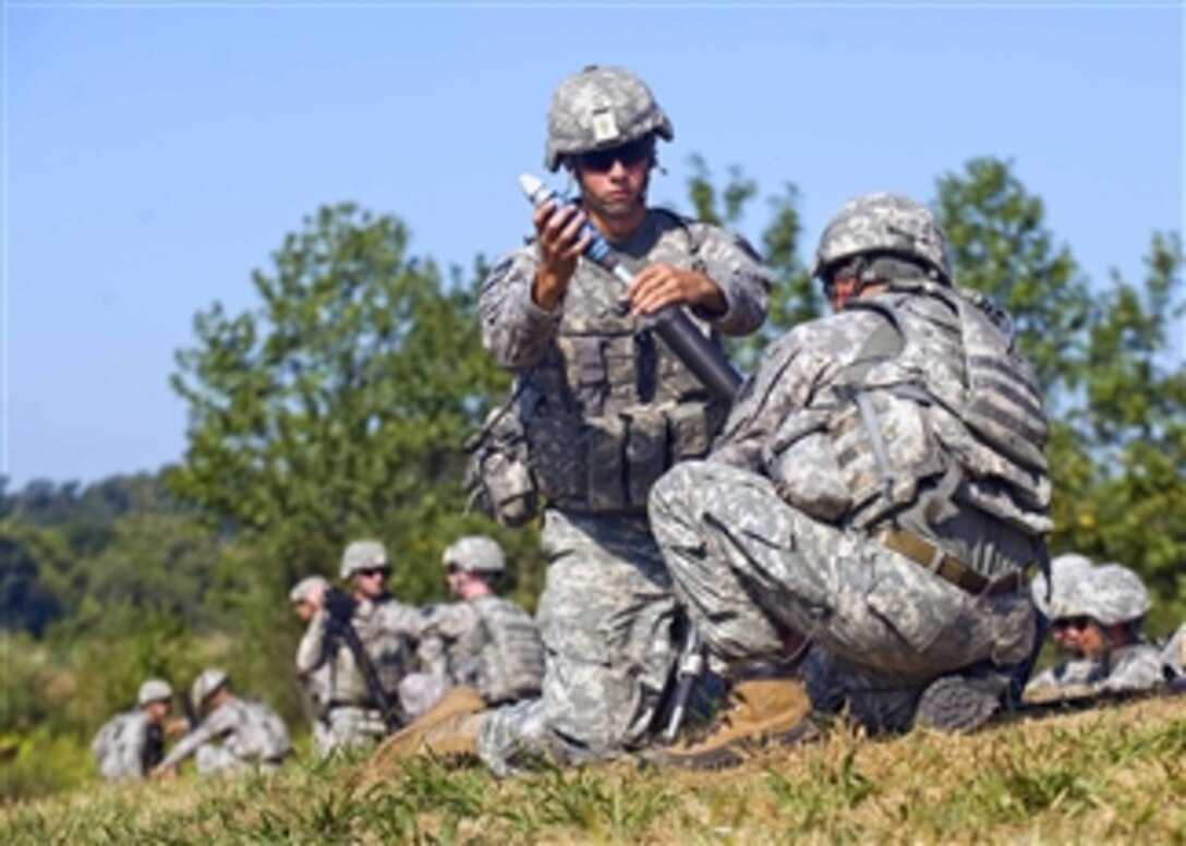 U.S. Army Pfc. Joseph Guzman, 1st Battalion, 181st Infantry Regiment, prepares to drop a 60mm mortar to launch at fixed targets at Camp Atterbury Joint Maneuver Training Center, Indiana, on August 31, 2010.  The Massachusetts National Guard unit is training to provide security to roughly a dozen provincial reconstruction teams across Afghanistan.  