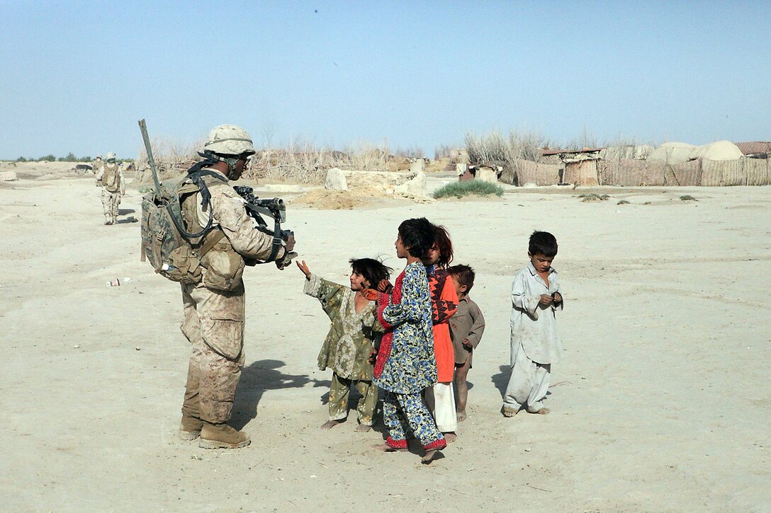 Lance Cpl. Demeterius Duncan, a mortarman with Weapons Platoon, Company B, 1st Light Armored Reconnaissance Battalion, passes out candy to the local children during a patrol at Shabu, Afghanistan, Sept. 15. The Marines with the cooperation of the locals have found the largest drug cache in their area with approximately 60 kilos of processed drugs.