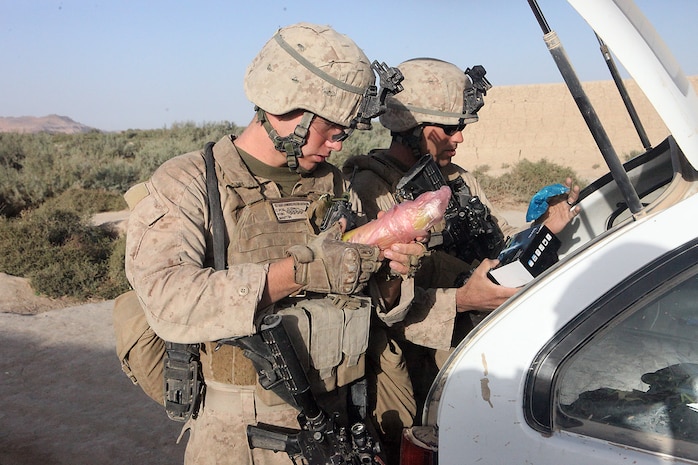 Lance Cpl. Garrett Mellor, a team leader, and Lance Cpl. Zach Martin, a mortarman, both with Weapons Platoon, Company B, 1st Light Armored Reconnaissance Battalion search a vehicle at a vehicle checkpoint in Shabu, Afghanistan, Sept. 15. In the village, Marines stop at random roads and set up vehicle check points to search for any Taliban movement, drugs or weapons.