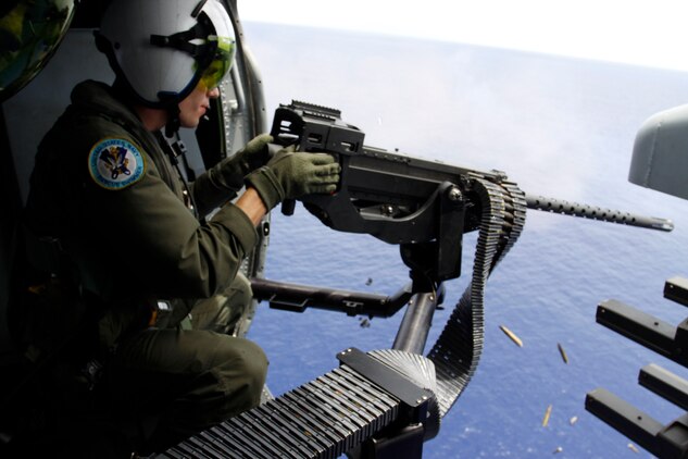 Petty Officer 3rd class Thomas Owens, a Helicopter Sea Combat Squadron 25 attack weapon system missile technician, fires an M2 .50-caliber machine gun during a live-fire sink exercise as part of exercise Valiant Shield 2010, Monday. The training required supporting units to alternate firing at the former USS Acadia at different times throughout the day in an attempt to sink it.