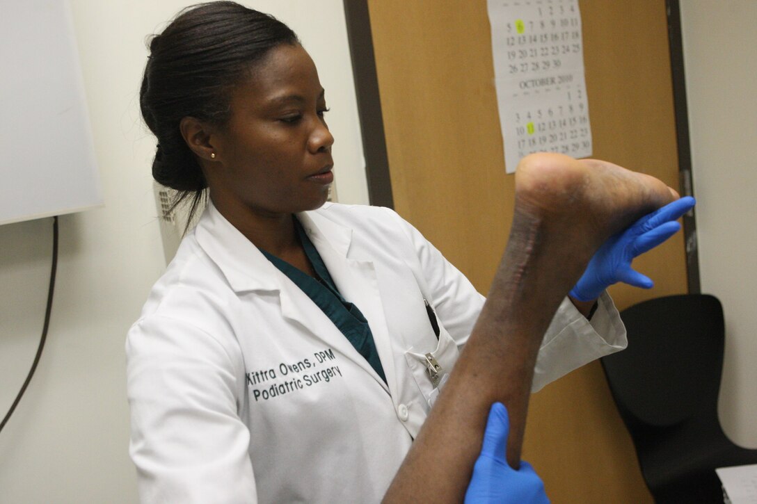 Navy Lt. Kittra Owens, podiatry department head for Naval Hospital Camp Lejeune, examines a recently torn achilles tendon, Sept. 16. Owens is one of 15 active-duty Navy podiatrists and one of two at NHCL.