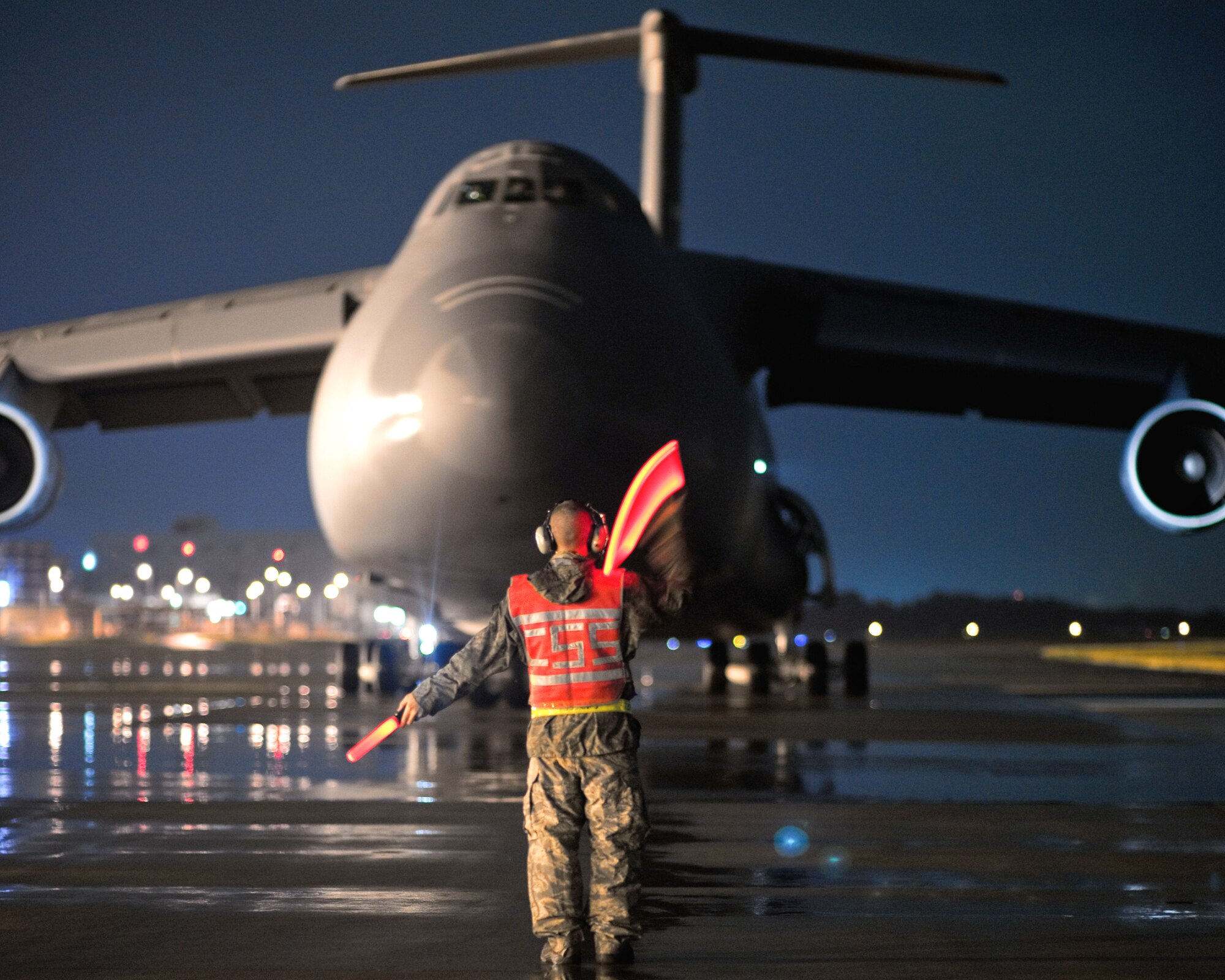 YOKOTA AIR BASE, Japan -- Staff Sgt. Dustin McComas, 730th Air Mobility Squadron, marshals a C-5 Galaxy aircraft here Sept. 15. As the airlift hub of the western Pacific, Yokota Airmen work 24/7 operations to keep inbound and outbound aircraft running. (U.S. Air Force photo/Osakabe Yasuo)
