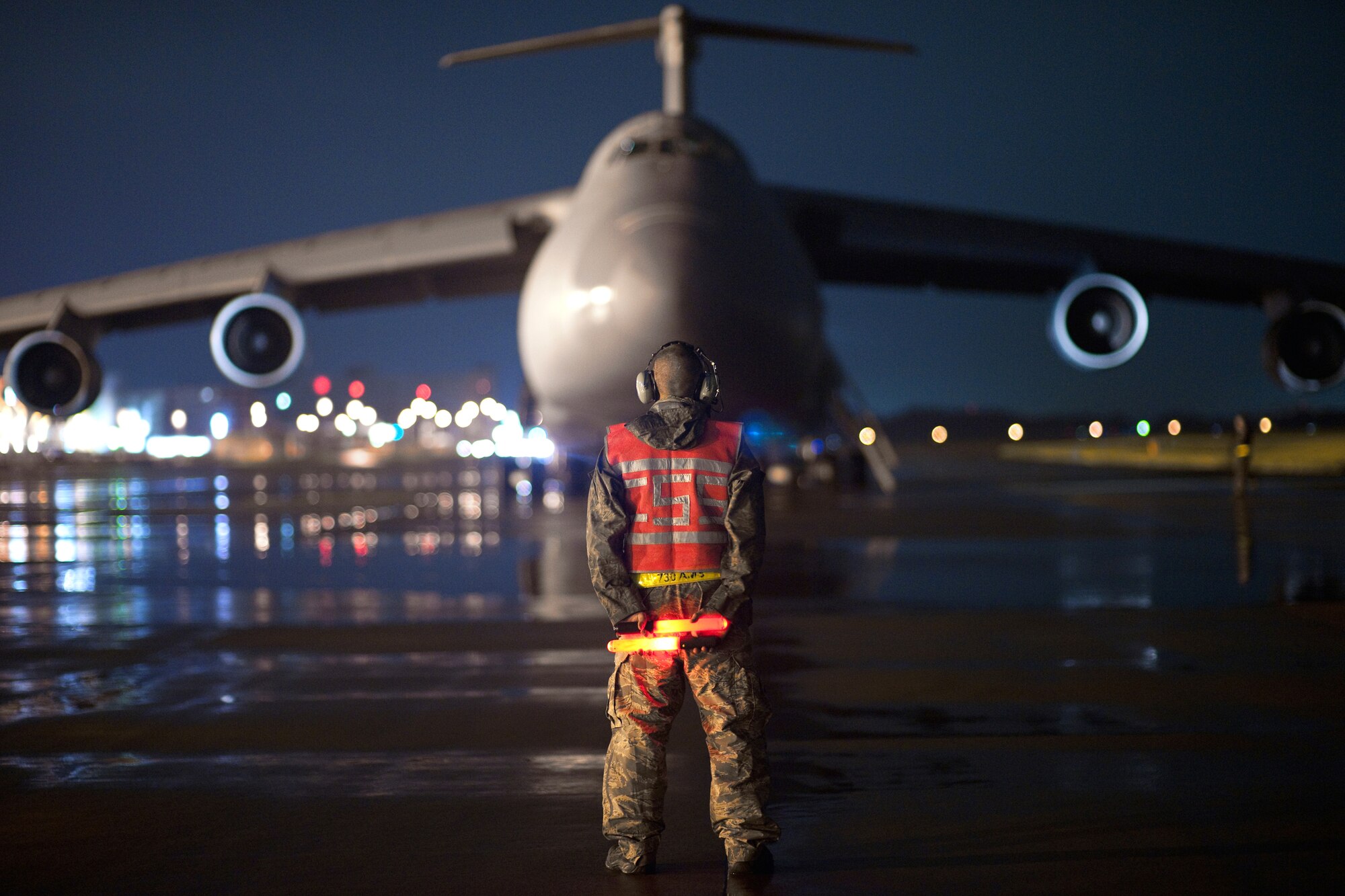 YOKOTA AIR BASE, Japan -- Staff Sgt. Dustin McComas, 730th Air Mobility Squadron, awaits for marshaling a C-5 Galaxy aircraft here Sept. 15. As the airlift hub of the western Pacific, Yokota Airmen work 24/7 operations to keep inbound and outbound aircraft running. (U.S. Air Force photo/Osakabe Yasuo)