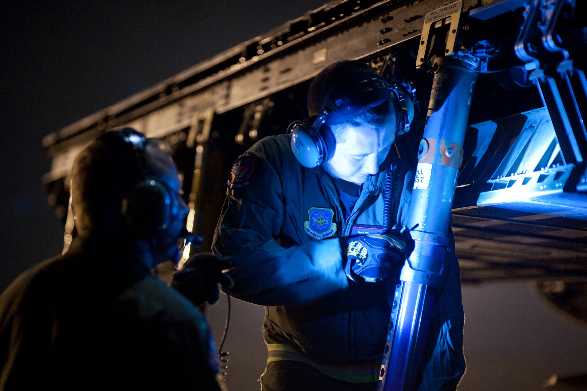 YOKOTA AIR BASE, Japan -- Airman 1st Class Tory Steen, 22nd Airlift Squadron, adjusts a stand poles for loading pallets by K-loader here Sept. 15. Airman Steen deploys from the 22nd Airlift Squadron, Travis Air Force base as the loadmaster of C-5 Galaxy. (U.S. Air Force photo/Osakabe Yasuo)