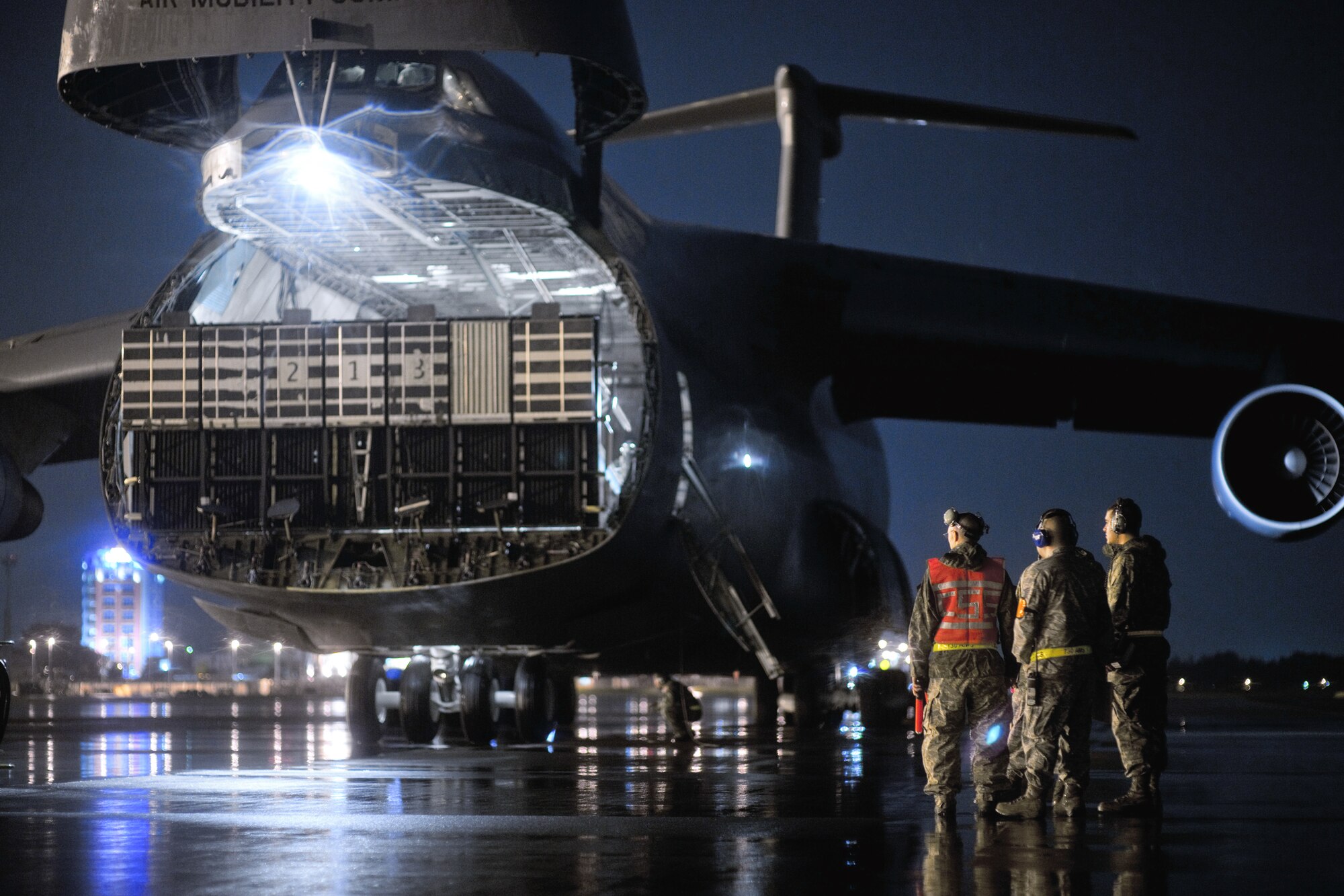 YOKOTA AIR BASE, Japan -- Members from the 730th Air Mobility Squadron observe a C-5 Galaxy aircraft with nose visor raised on the flightline here Sept. 15. Yokota Airmen are always standing by for inbound and outbound aircraft running 24/7 operations. (U.S. Air Force photo/Osakabe Yasuo)