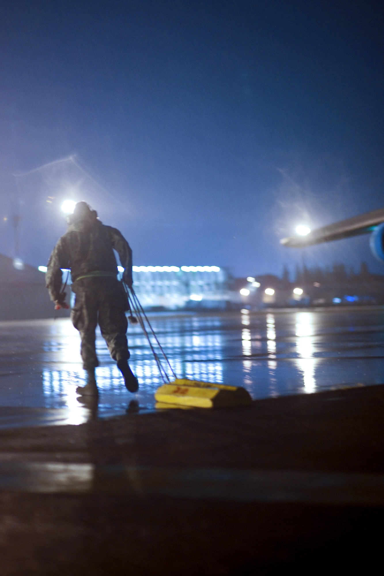 YOKOTA AIR BASE, Japan -- A member from the 730th Air Mobility Squadron sets up a wheel chocks after the C-5 Galaxy aircraft lands here Sept. 15. As the airlift hub of the western Pacific, Yokota Airmen work 24/7 operations to keep inbound and outbound aircraft running. (U.S. Air Force photo/Osakabe Yasuo)