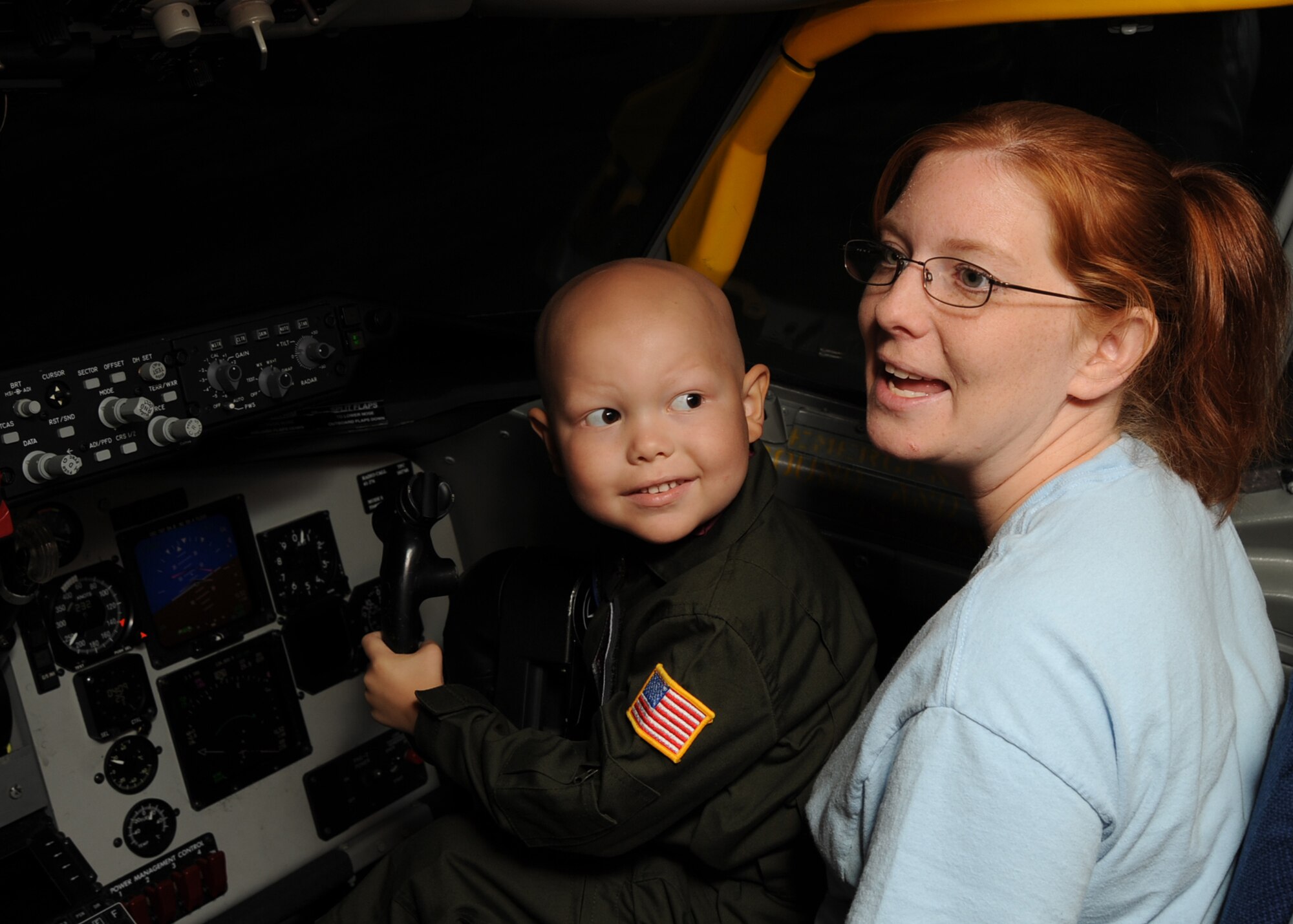 Five-year-old Jesse Whiteside “Pilot For a Day” participant, sits in a flight simulator with Amy Whiteside, his mother, at the simulator training facility, McConnell Air Force Base, Kan., Sept. 16, 2010.  Jesse, who was recently diagnosed with Acute Lymphoblastic Lymphoma, was invited to the base by members of the 384th Air Refueling Squadron as part of the Pilot For a Day program, an Air Force program that allows medically-challenged youth a chance to tour the base.  (U.S. Air Force photo/Staff Sgt. Dallas Edwards)