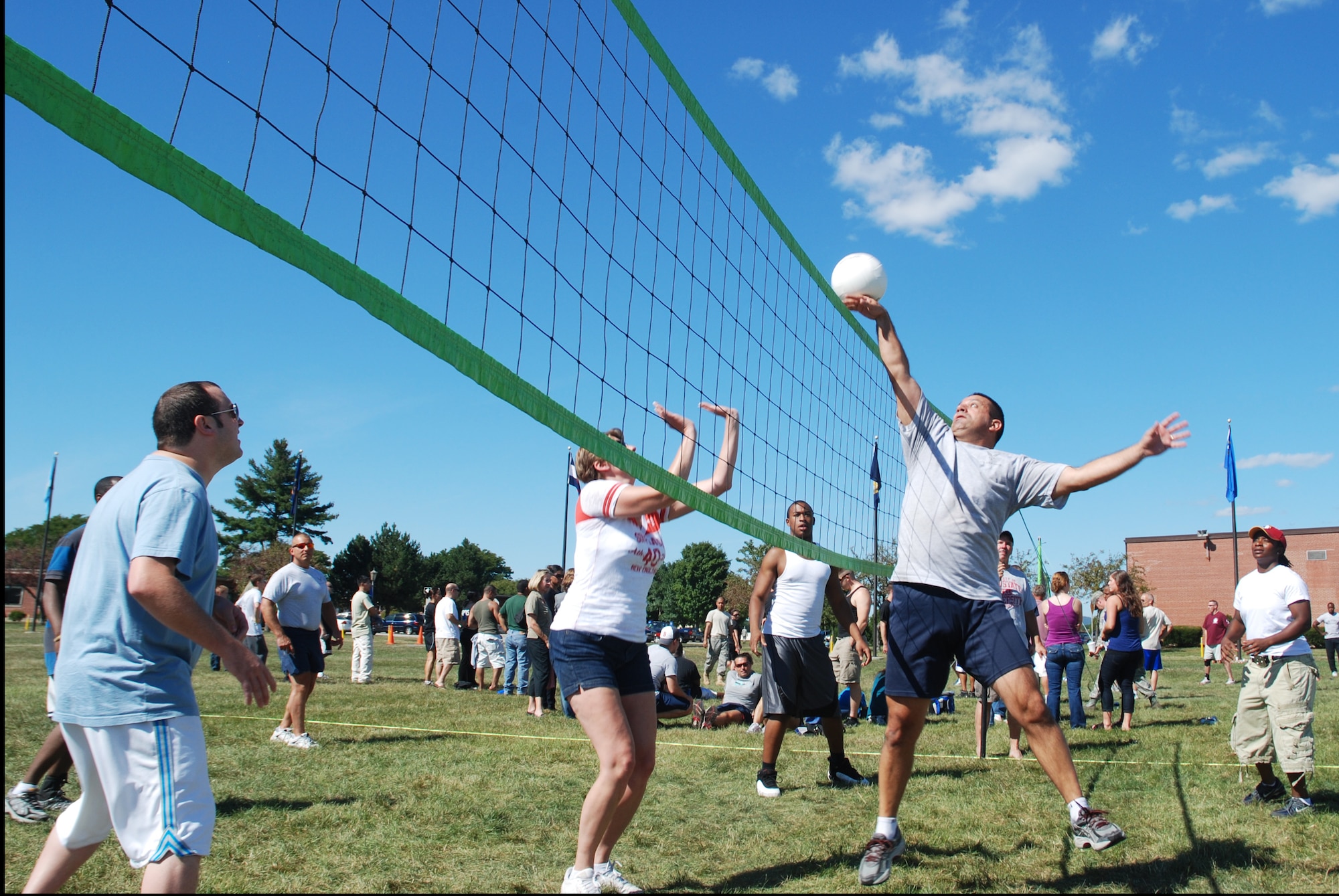Senior Master Sgt. Nelson Serrao, 439th Airlift Wing Command Post, knocks the ball back over the net during the intersquadron volleyball tournament at Family Day, Sept. 11.  