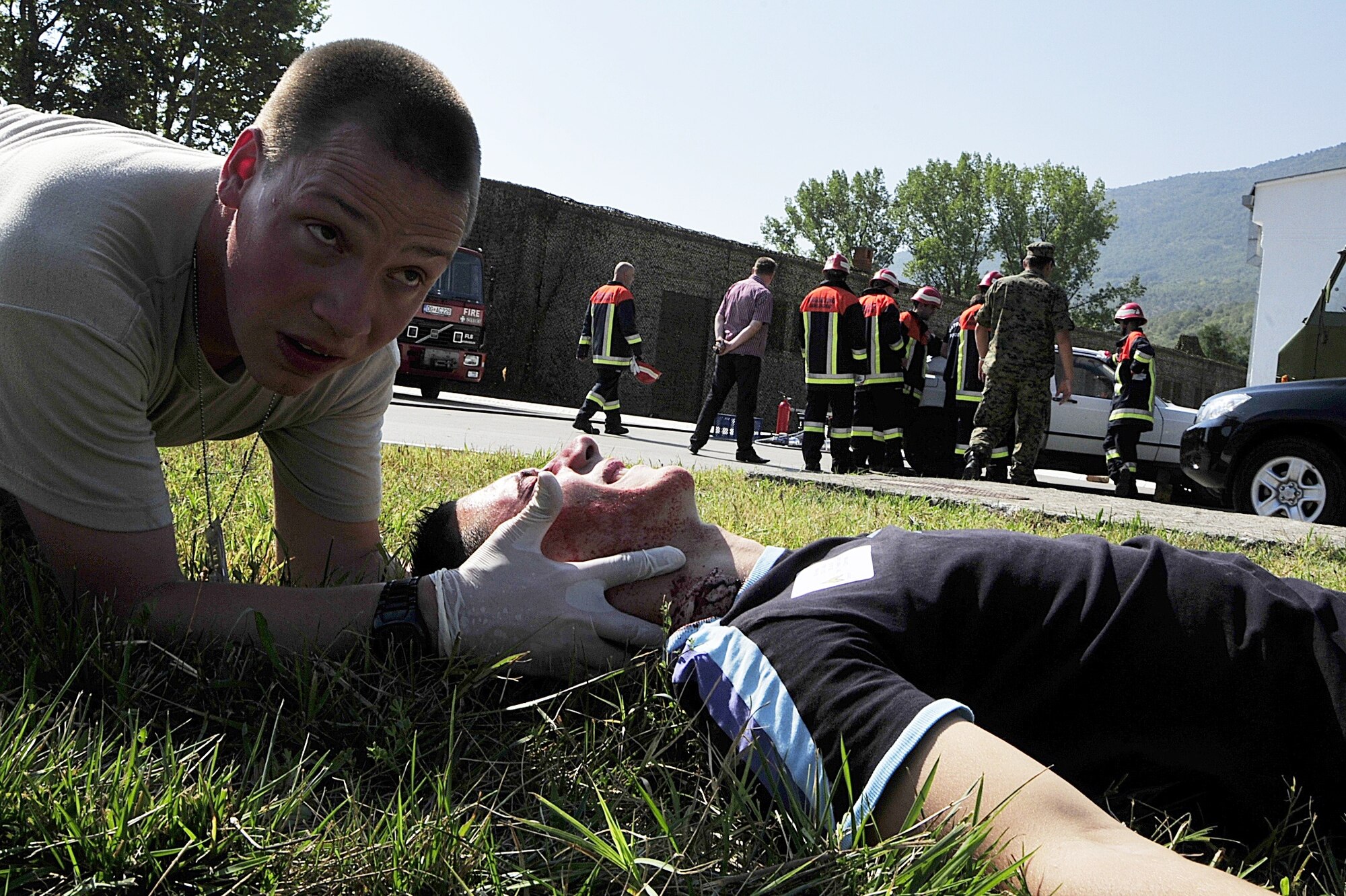 (left to right) United States Air Force Staff Sgt. Jacob Good, a medical technician from the 48th Medical Operations Squadron at RAF Lakenheath, England, stabilizes the head of someone covered with make-up to represent a specific injury from a mock traffic accident at Danilovgrad Army Base, Montenegro, Sept. 15. This emergency response scenario was part of MEDCEUR 10, a medical training exercise in central and eastern Europe, that has armed forces participants from ten nations. These exercises will enable the medical armed forces members to learn from each other and be better prepared for real-world situations. For more information, visit www.usafe.af.mil/medceur.asp and www.odbrana.gov.me. (U.S. Air Force photo/Airman 1st Class Tiffany Deuel)