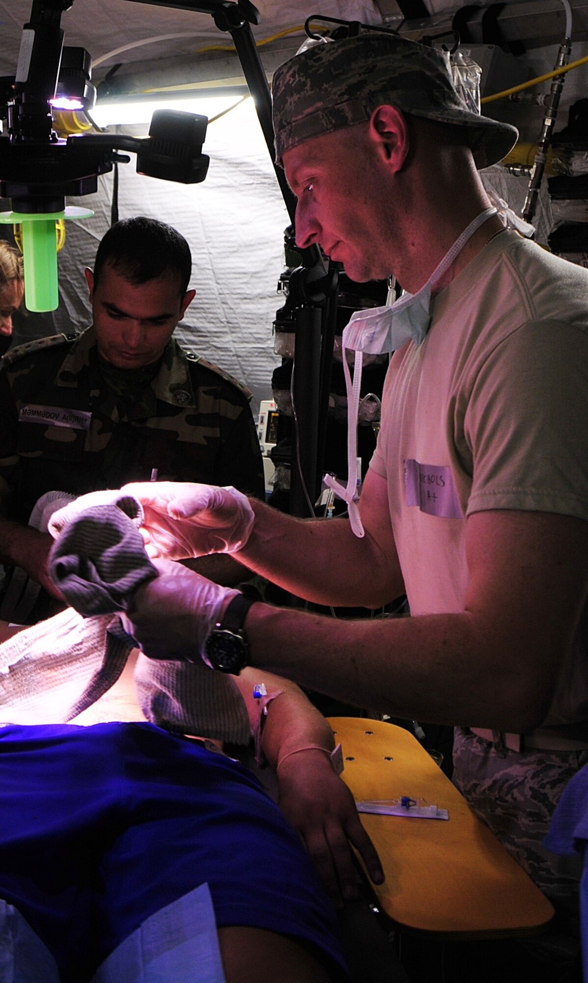 United States Air Force Maj. Shawn Nichols (right), a surgeon from the 48th Aerospace Medical Squadron at RAF Lakenheath, England, unwraps gauze from an object made to look as if it was impaled in a stomach, as Azerbaijani Capt. Rashad Mammadov holds an oxygen mask over the face of the person acting as the victim of a mock traffic accident at Danilovgrad Army Base, Montenegro, Sept. 15. This exercise is part of MEDCEUR 10, a medical training exercise in central and eastern Europe, in which military medical servicemembers from ten nations train together to save as many lives as possible and to be better prepared for real-world events. For more information, visit www.usafe.af.mil/medceur.asp and www.odbrana.gov.me. (U.S. Air Force photo/Airman 1st Class Tiffany Deuel)