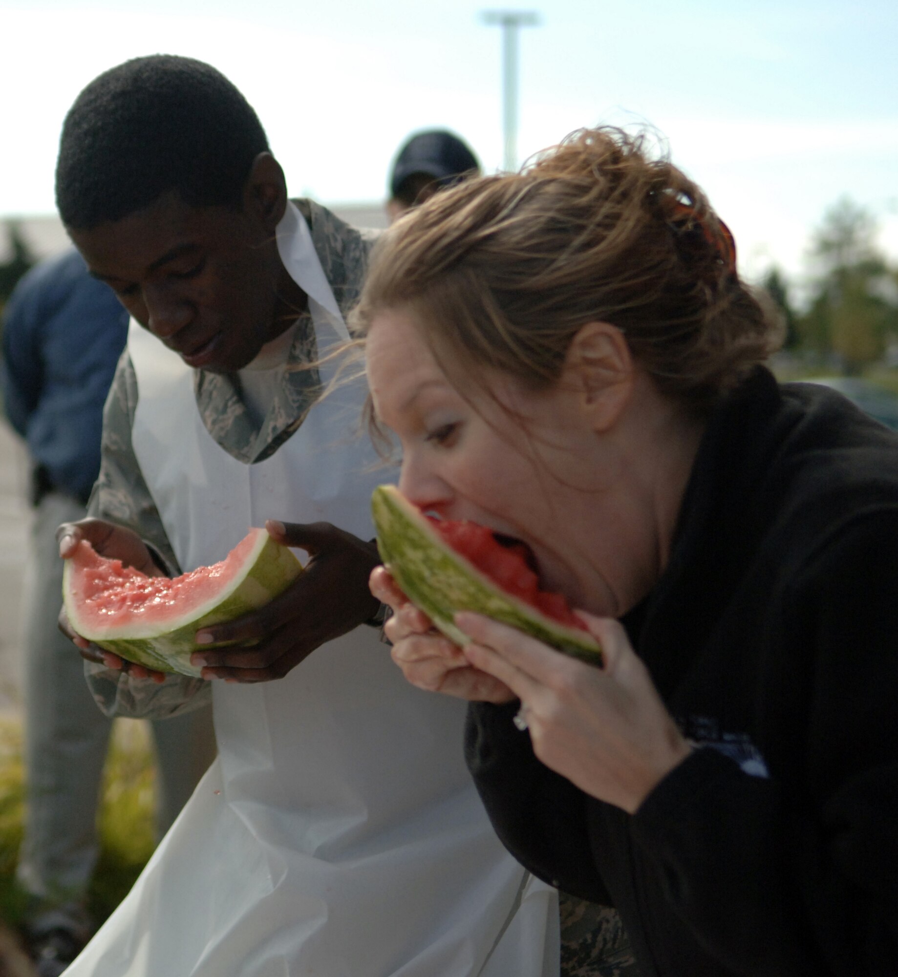 Airman 1st Class Jonathan Brown (left), 319th Civil Engineer Squadron and Leah Melquist, Health and Wellness Center, devour watermelon Sept. 16, during a watermelon eating contest at the Grand Forks Air Force Base’s commissary Sept. 17. The HAWC held the contest to promote the importance of eating fruits and vegetable. Nathan Bennett, 319th Force Support Squadron, won the contest after eating a half a watermelon in less than 10 minutes.  (U.S. Air Force photo by Airman 1st Class Rachel Waller)