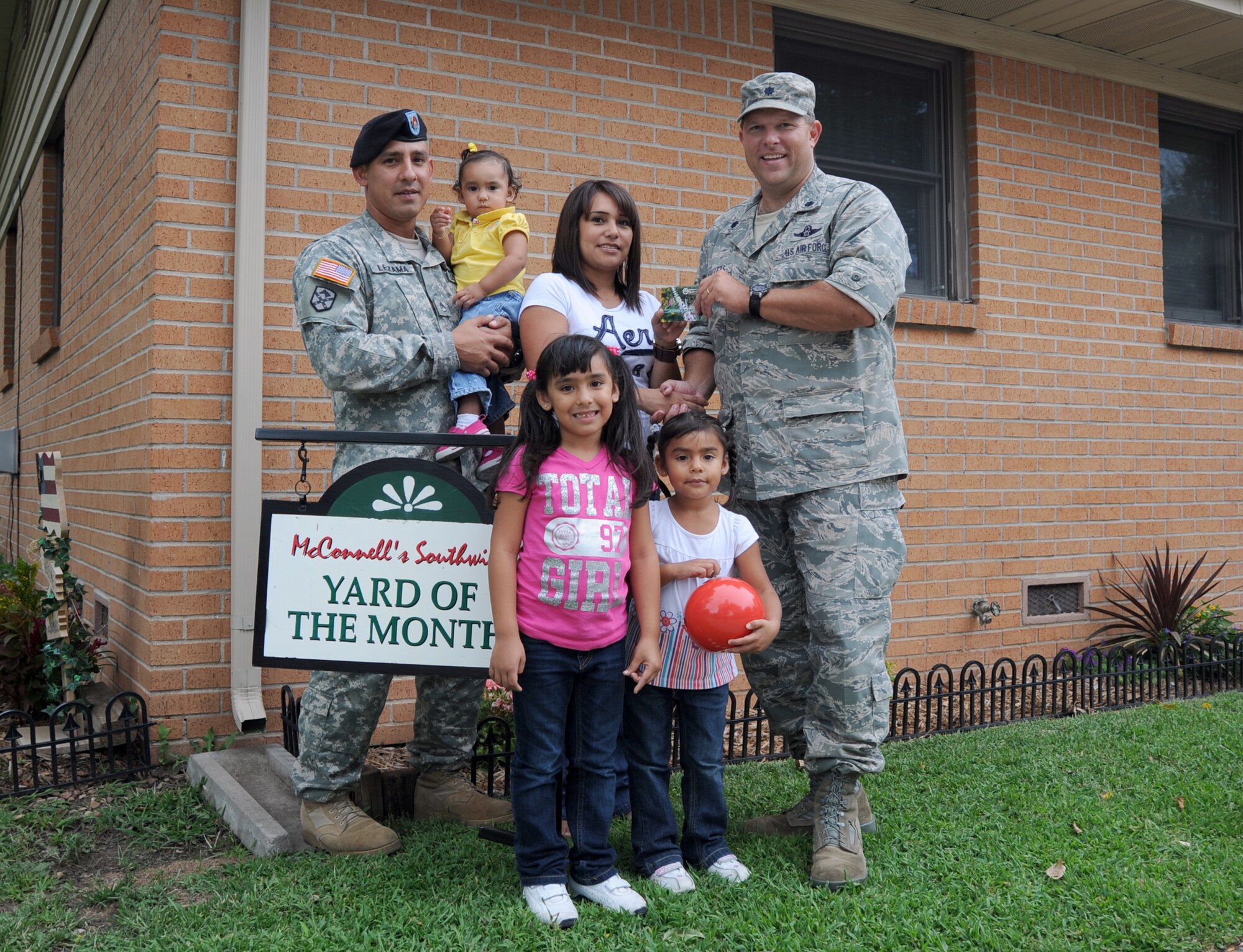 Lt. Col. Robert Mallets, 22nd Mission Support Group deputy commander, recognizes Staff Sgt. Jose Lezama, U.S. Army Reserve, 89th Sustainment Brigade, his wife,Flor, and his children, Alyssa, age 1, Arianna, age 5, and Alma, age 4,  for winning the yard of the month, Sept. 2, 2010.  The Lezama family won yard of the month for September, which is the final month of this recognition for 2010.  The Yard of the Month recognizes the best landscaping and lawn care in base housing. (U.S. Air Force photo/Staff Sgt. Dallas Edwards)