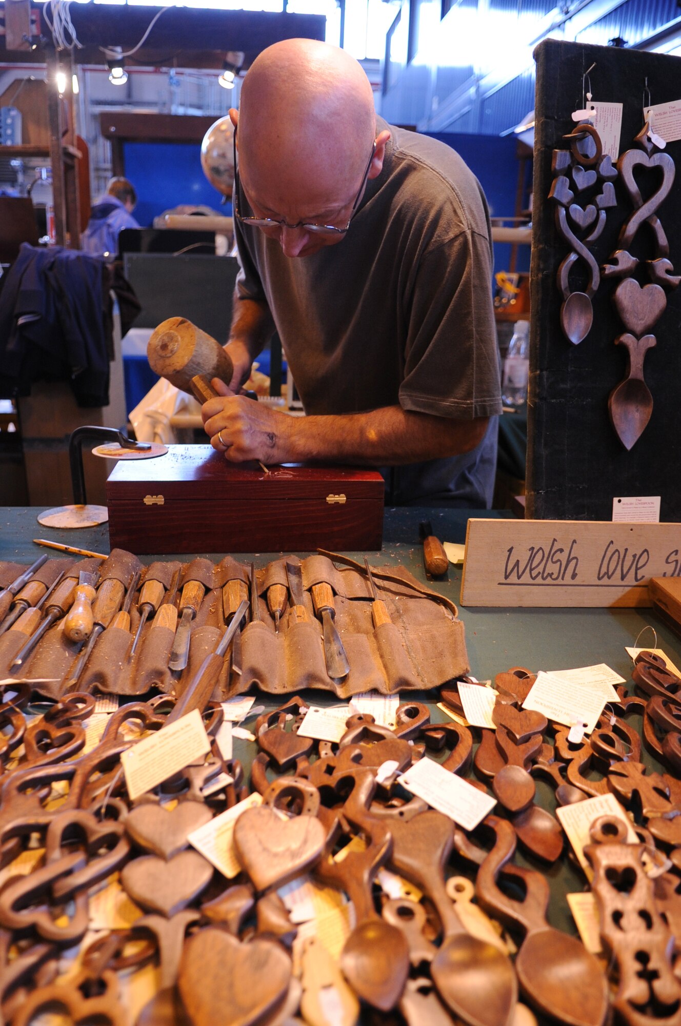 Yvon Tanguy, wooden crafts vendor, carves a design on a wooden handicraft at the Ramstein Welfare Bazaar, Ramstein Air Base, Germany, Sept. 16, 2010. For more than four decades, the Kaiserslautern Military Community has benefited from the Ramstein Welfare Bazaar. This annual event dates back to 1965 and has grown into one of the largest military bazaars in Europe. (U.S. Air Force photo by Airman 1st Class Brittany Perry)