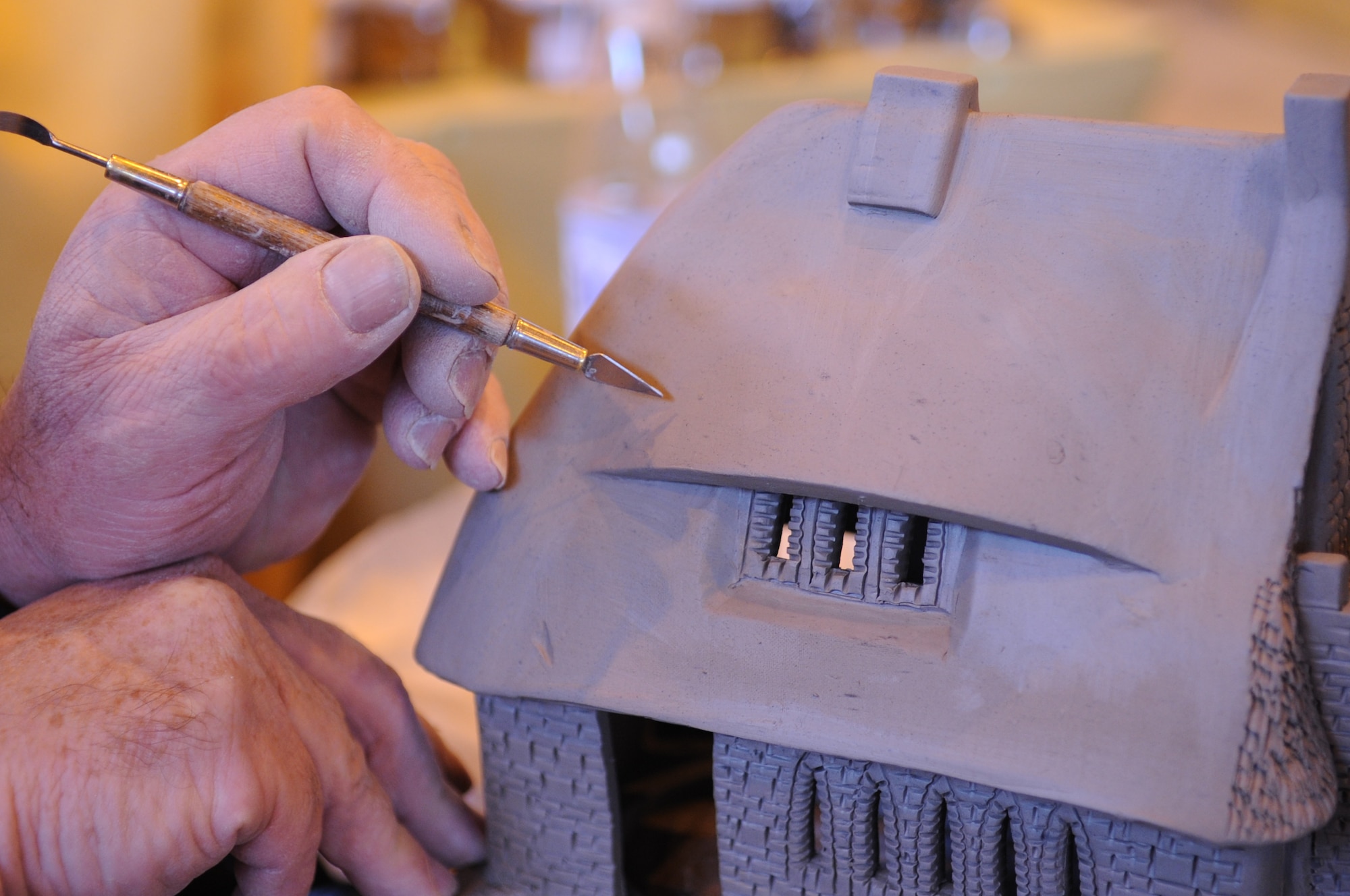Leonardo Canziani, bone china vendor, sculpts a bone china cottage at the Ramstein Welfare Bazaar, Ramstein Air Base, Germany, Sept. 16, 2010. For more than four decades, the Kaiserslautern Military Community has benefited from the Ramstein Welfare Bazaar. This annual event dates back to 1965 and has grown into one of the largest military bazaars in Europe. (U.S. Air Force photo by Airman 1st Class Brittany Perry)