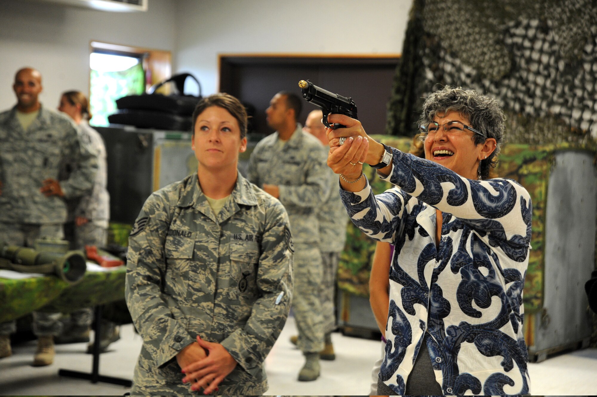 Staff Sgt. Jessica McDonald, 22nd Security Forces Squadron unit trainer, watches as Susan Allardice, wife of Lt. Gen. Robert Allardice, 18th Air Force commander, tries a Beam Hit System, at the combat skills training facility, McConnell Air Force Base, Kan., Sept. 8, 2010.  A Beam Hit System is a training simulator that uses laser-mounted weapons and a video screen to simulate situations where deadly force might be necessary.  Mrs. Allardice visited key facilities and members of McConnell to familiarize herself with base practices and available services for military members and their families.  (U.S. Air Force photo/Staff Sgt. Dallas Edwards)