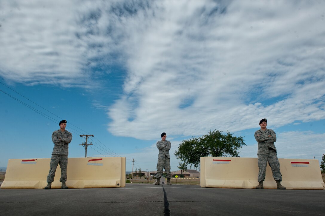 ELLSWORTH AIR FORCE BASE, S.D. - (From left) Senior Airmen Jonathan Byron, Chadwick Richardson and Isaac Bliek demonstrate how the 28th Security Forces Squadron utilizes barriers to block road access into the play areas.  Play areas are used during exercises to allow Airmen an area to practice their skills in a warlike environment. Crossing these barriers without authorization disrupts base exercises and interrupts crucial training. All three Airmen are Security Forces leaders in the 28th SFS. (U.S. Air Force photo by/Tech. Sgt. Nathan Gallahan)