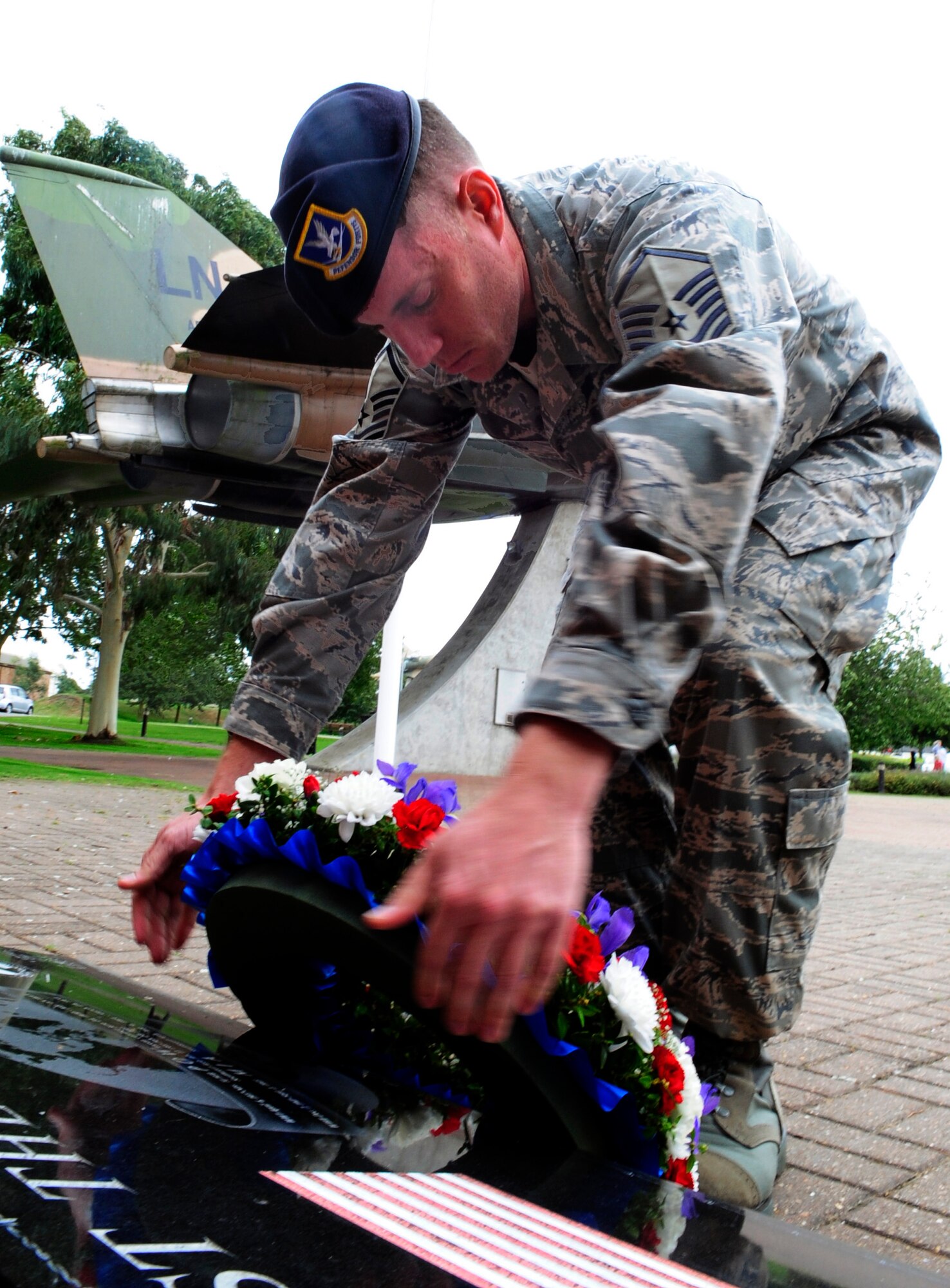 RAF MILDENHALL, England -- Master Sgt. James Robbins, 48th Security Forces Squadron superintendent of logistics, lays a Prisoner of War/Missing in Action wreath at the "Lest we Forget" wall at RAF Lakenheath Sept. 14. This was the last wreath laid at the end of the Rolling Thunder Motorcycle Rally, that was done as part of POW/MIA Rememberance Week, which started on RAF Mildenhall. (U.S. Air Force photo/Senior Airman Ethan Morgan)
