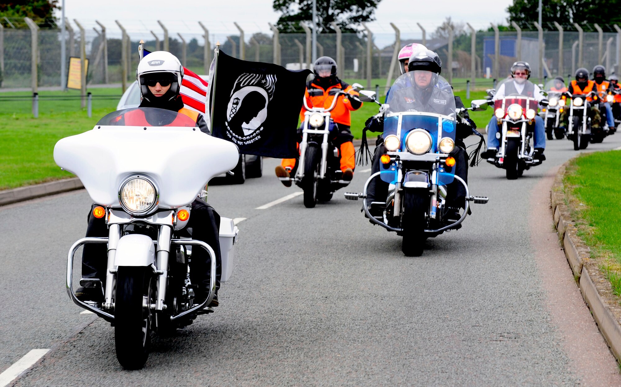 RAF MILDENHALL, England -- Members of the Rolling Thunder Motorcycle Rally cruise through here during their ride for Prisoner of War/Missing in Action Remembrance Week Sept. 14. The members are led by Tech. Sgt. Jonathan Richichi, 48th Communications Squadron infrastructure NCO, who carries the POW/MIA and American flags on his bike. (U.S. Air Force photo/Senior Airman Ethan Morgan)