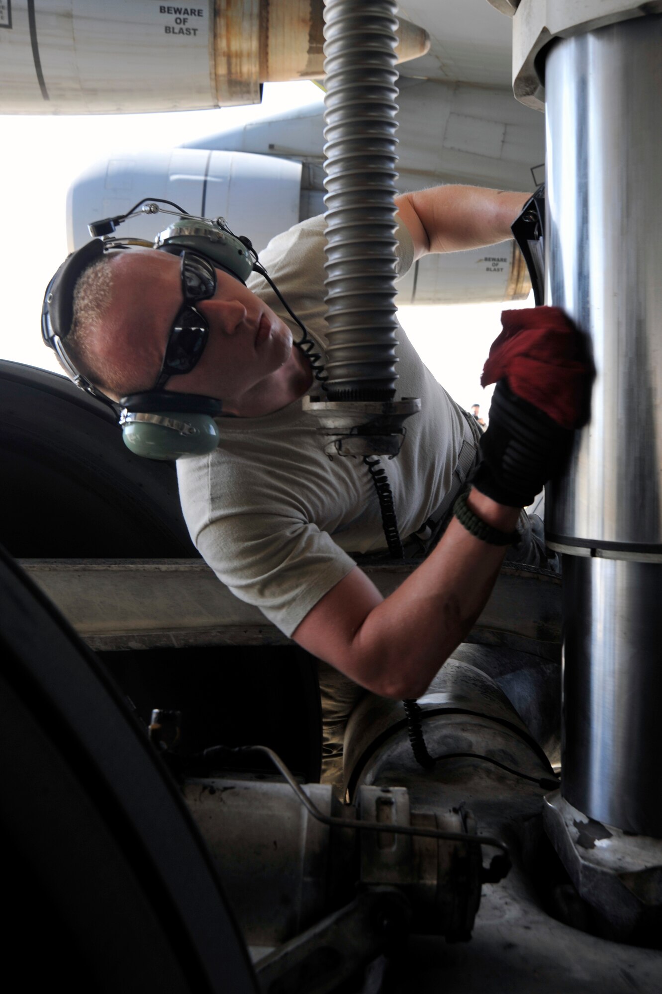 Airman 1st Class Joshua Walling, 521st Air Mobility Operations Group hydraulics specialist, wipes the sand off a shock absorber from one of the C-5 Galaxy's five landing gears during a preflight inspection Sept. 13, 2010, at Al Asad Air Base, Iraq. Airman Walling is preparing the aircraft to fly to Balad AB to receive cargo.(U.S. Air Force photo by Senior Airman Perry Aston) (Released)