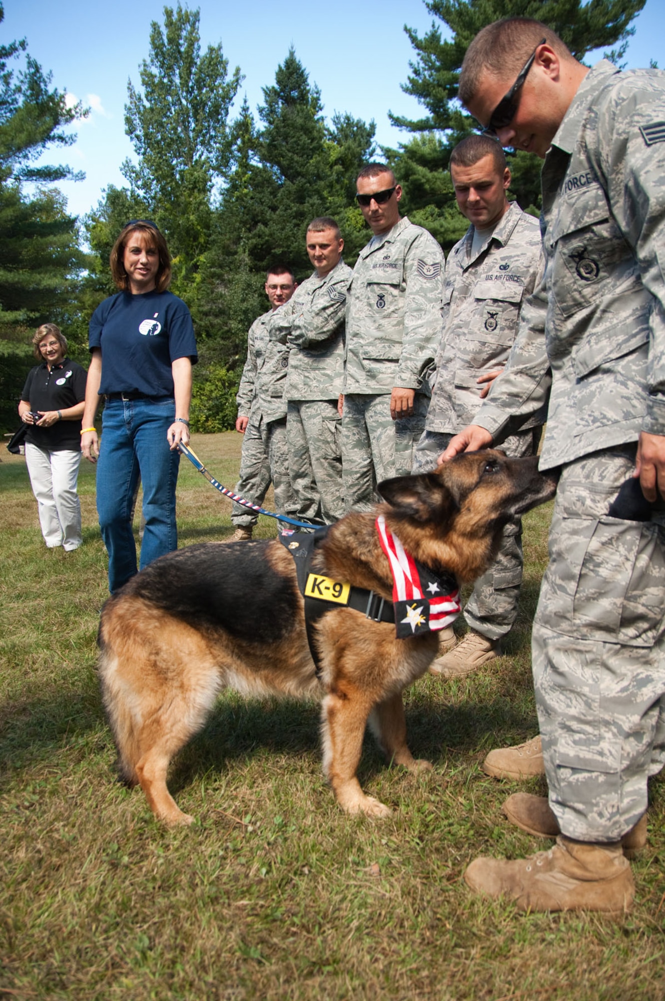 ASHLAND, N.H. – Senior Airman Robert Aikins (right), a military working dog handler from the 66th Security Forces Squadron, pets former military working dog, Lex, as other security forces members and Rachel Lee, Lex’s owner, stand by on Sept. 11. Hanscom’s military working dogs and their handlers traveled to New Hampshire to take part in a demonstration and gala to honor a Marine Cpl. Dustin Lee, a military working dog handler who was killed in Afghanistan in 2007. The honored guest was Lex, Corporal Lee’s working dog. (U.S. Air Force photo by Rick Berry)