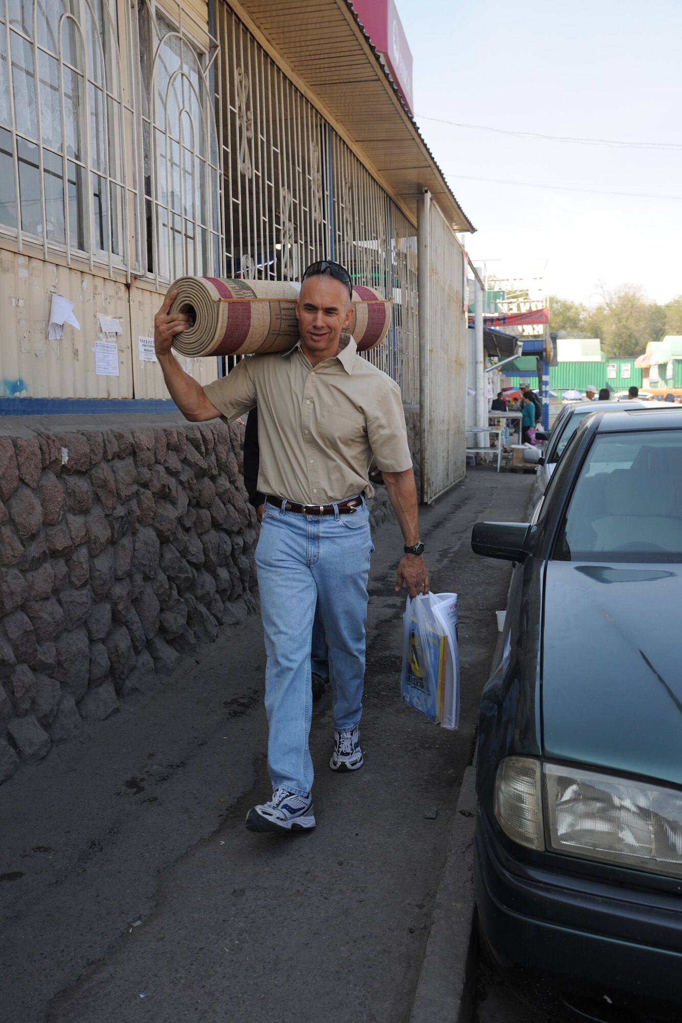 BISHKEK, Kyrgyzstan - Chief Master Sgt. Mark Villella, Air Forces Central Command Chief, carries a rug purchased for Marble Village Kindergarten Sept. 15.  Chief Villella went on a Humanitarian Assistance mission with Airmen from the Transit Center at Manas and assisted in donating $10,000 worth of school furniture.  (U.S. Air Force photo/Staff Sgt. Nathan Bevier)