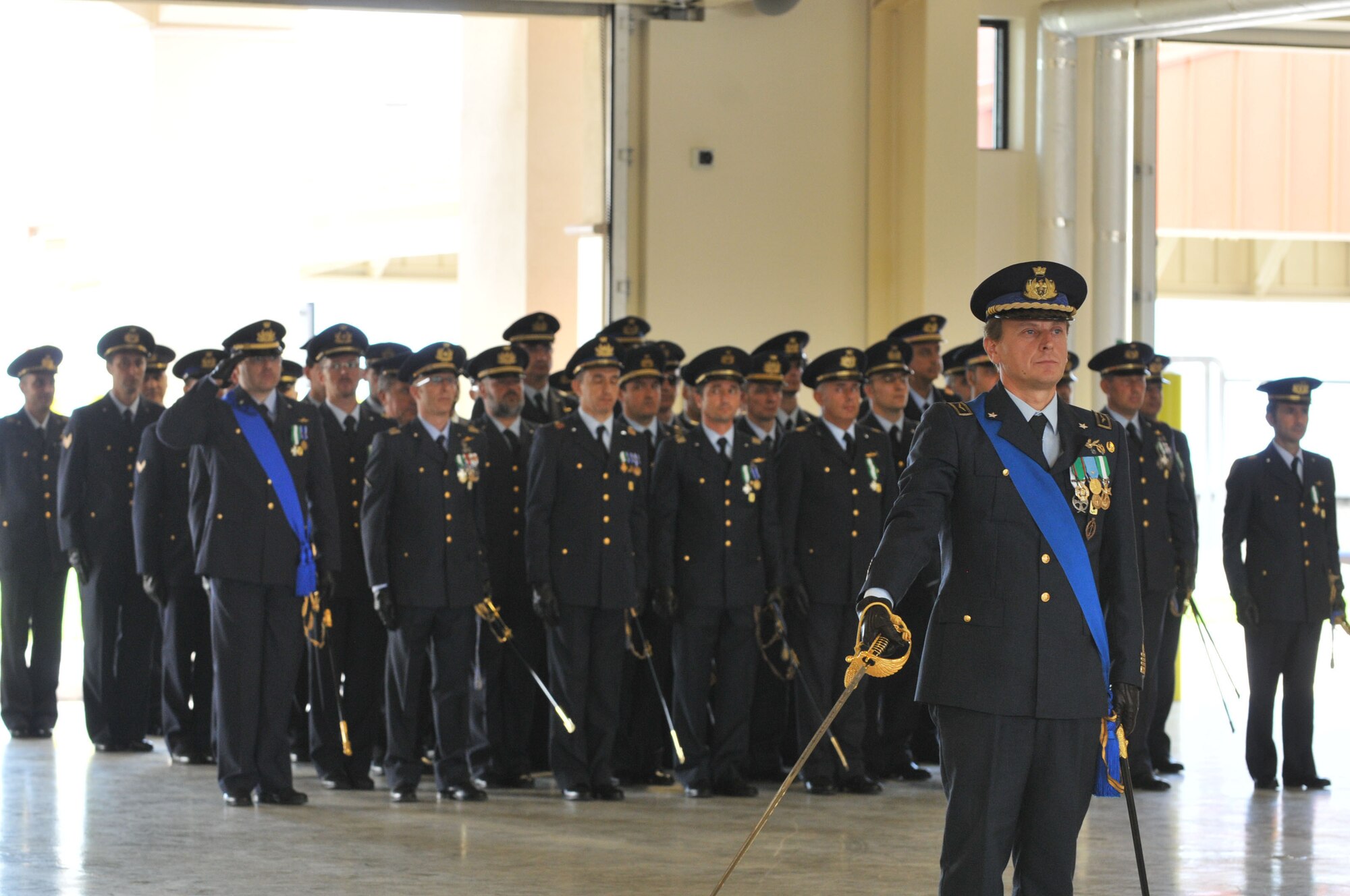 Colonel Luca Cappelli accepts command of the Italian Air Force "Pagliano e Gori" Airport, from Col. Filippo Zampella, during a change of command ceremony at the Personnel Alert Holding Area Sept. 15. (U.S. Air Force photo/SSgt Mercedeskimble L. Crossland)