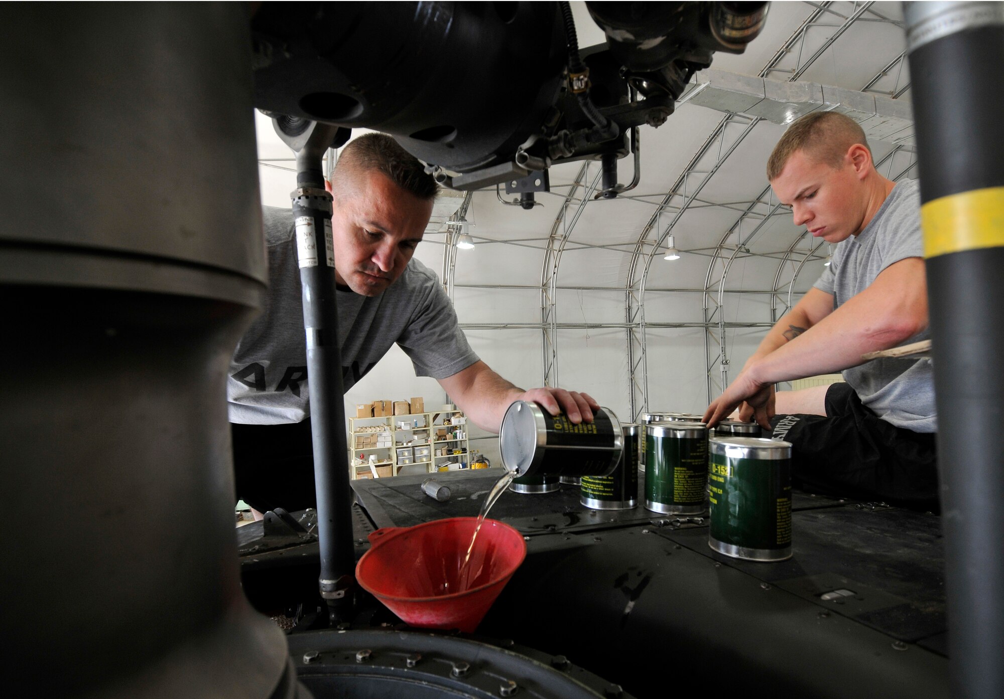 Army Sergeants Floyed Viles and Christopher Bergendahl, Charlie Company, 7th Battalion, 101st Aviation Regiment crew chiefs, refill a UH-60 Black Hawk’s transmission with oil after being replaced Sept. 10, 2010, Joint Base Balad, Iraq. UH-06 Black Hawk transmission holds approximately seven gallons of oil. Sergeant Viles is a native of Kansas City, Mo., deployed from Kansas National Guard, Kan. and Sergeant Bergendahl is a native of Enfield, Conn., deployed from Fort Campbell, Ky.  (U.S. Air Force photo/Staff Sgt. Phillip Butterfield)