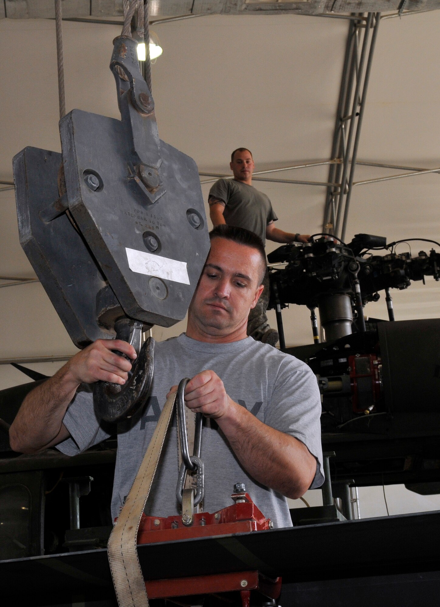 Army Sgt. Floyed Viles, Charlie Company, 7th Battalion, 101st Aviation Regiment crew chief, connects a main rotor blade to a crane while Spc. Robert Ruoho, Company C. crew chief waits to install the blade on the rotor after a transmission replacement Sept. 10, 2010, Joint Base Balad, Iraq. Charlie Company uses a crane to lift the titanium fiberglass blades into position. Sergeant Viles is a native of Kansas City, Mo., deployed from Kansas National Guard, Kan., and Specialist Ruoho is a native of Deltona, Fla., deployed from Fort Campbell, Ky. (U.S. Air Force photo/Staff Sgt. Phillip Butterfield)