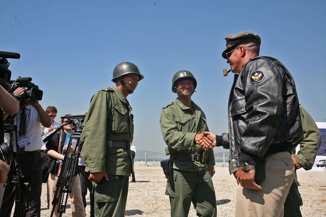 Marine Capt. Mike Borneo, company commander, Animal Company, Battalion Landing Team 1st Battalion, 7th Marines, 31st Marine Expeditionary Unit, dressed in period costume as the famous Gen. Douglas Macarthur, shakes hands with ROK Marine officers after the 60th anniversary reenactment of the landing at Incheon, Sept. 15, 2010. The event was held in front of thousands of spectators, and honored the veterans of the war.